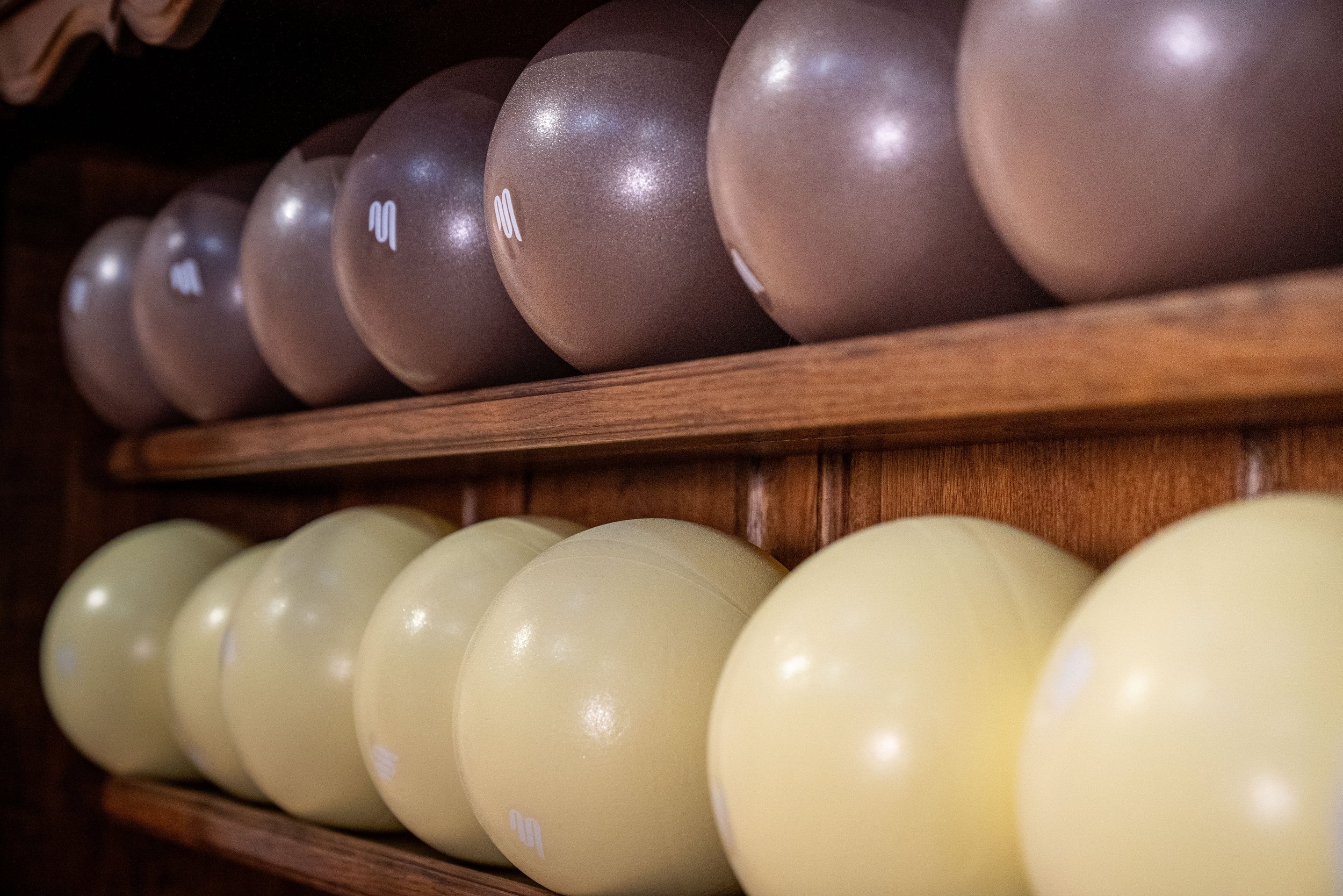 Des rangées d'œufs bruns et blancs rangés sur des étagères en bois.