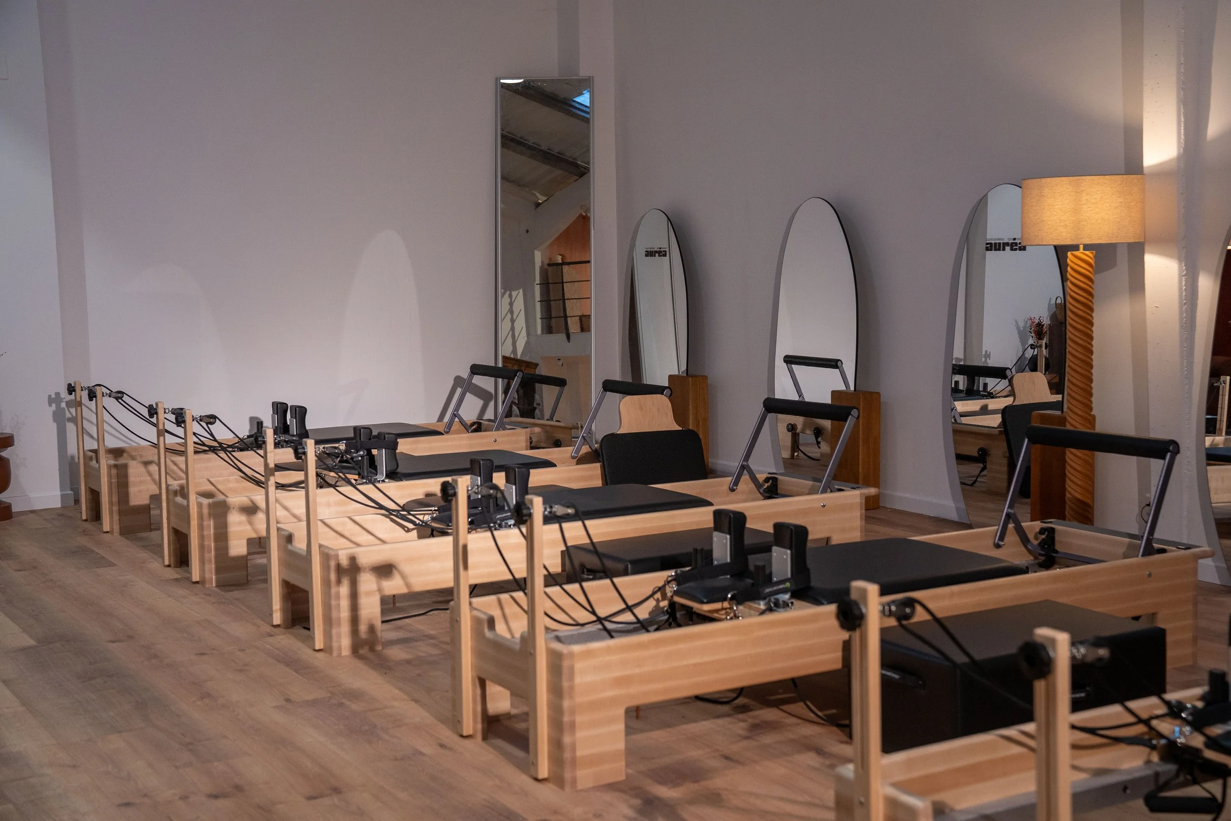 Enchainement de machine de Pilates Reformer en bois sur un parquet en bois dans le studio Auréa de Pilates, Reformer et Yoga à Marcq en Baroeul