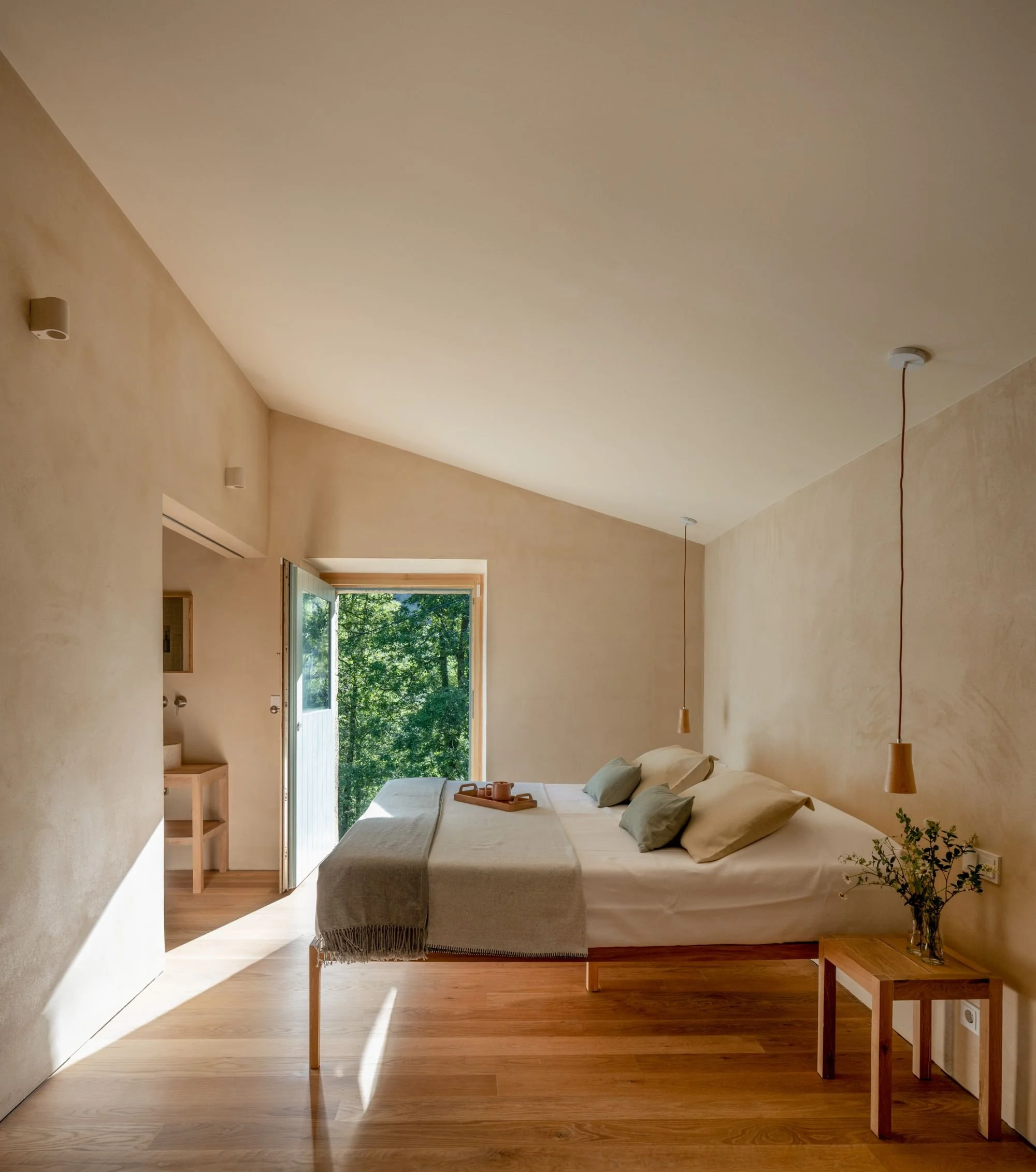 bedroom in a passivhaus of northen spain. Wooden bed, natural materials, sunlight entering through the windows