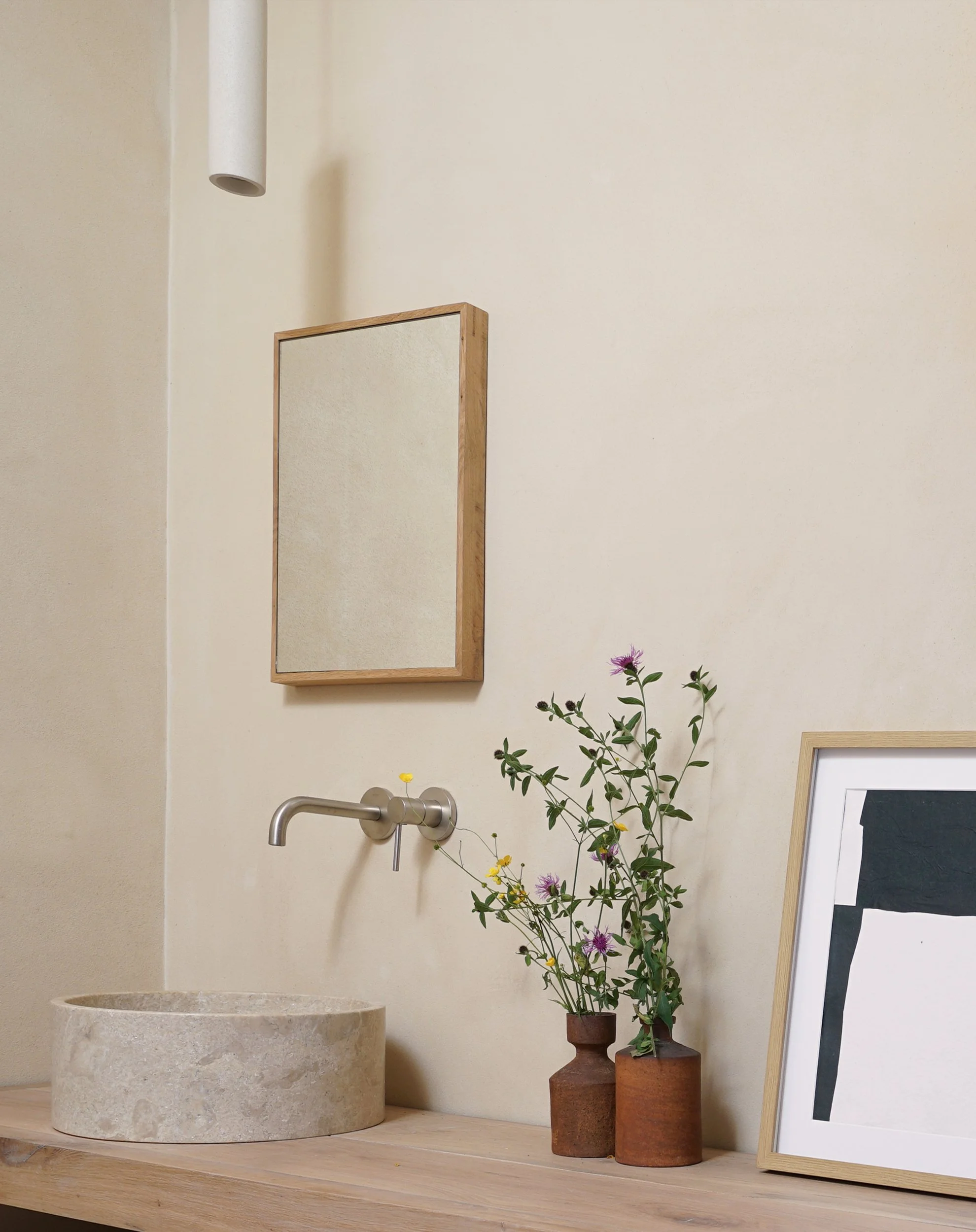 Baño de materiales naturales cal, piedra y lavamanos de madera