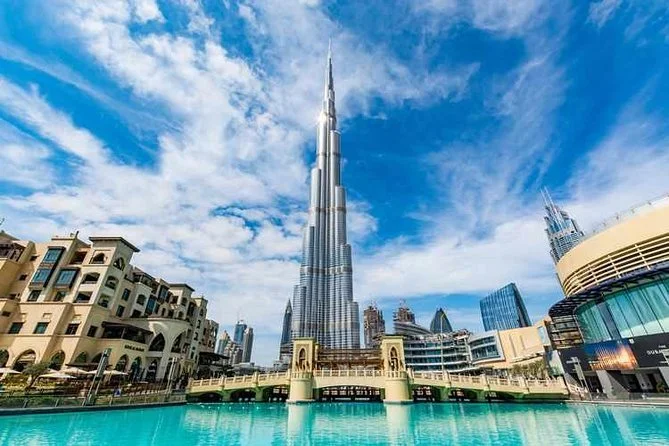 Skyline of Dubai with the Burj Khalifa skyscraper near a reflecting pool.