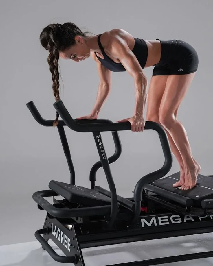 Woman in black sports bra and shorts doing a workout on a Mega Pro stepper machine.