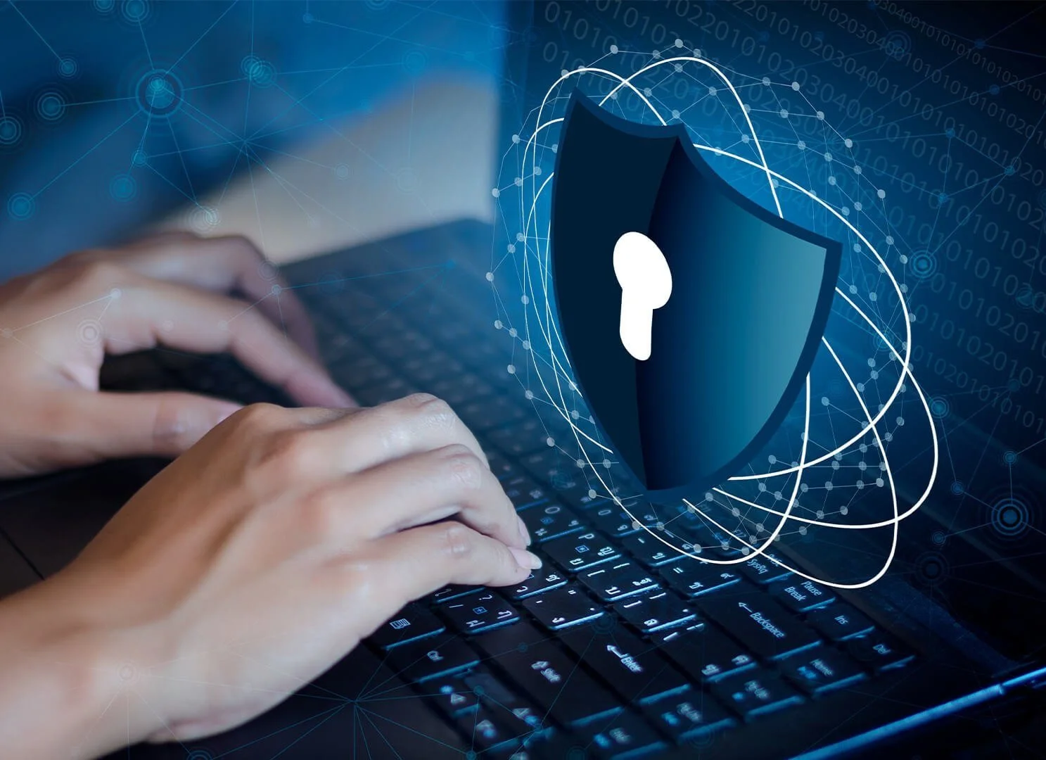 Hands typing on a laptop keyboard with a digital graphic of a shield with a keyhole and digital security icons in the foreground.