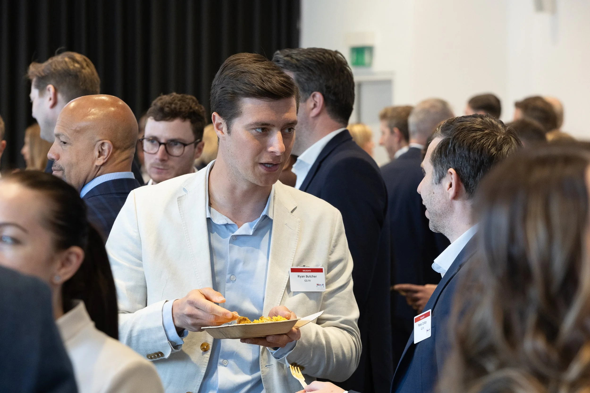 Business professionals at a networking event, engaging in conversation.