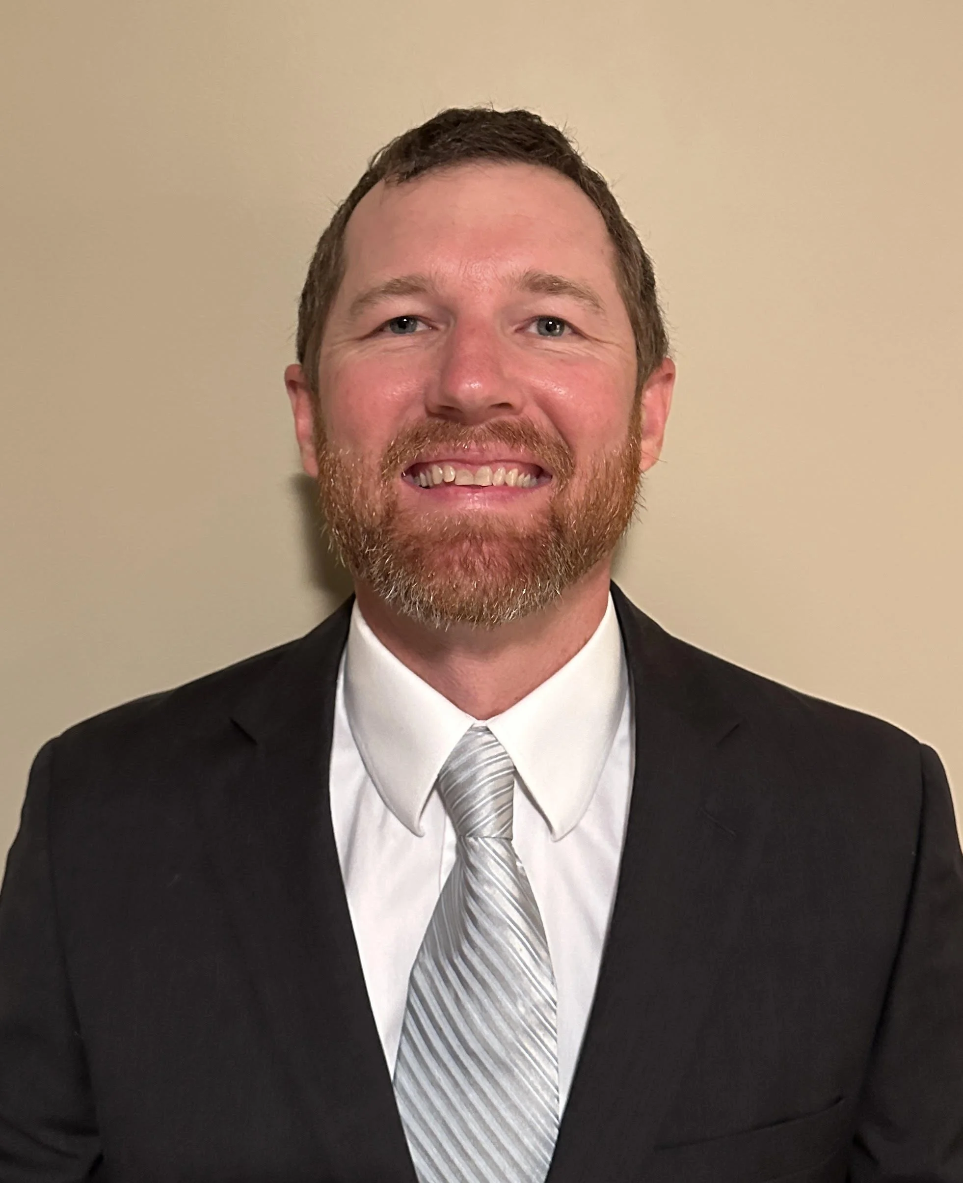 Silhouette of a person's head and shoulders, with short hair, facing forward.