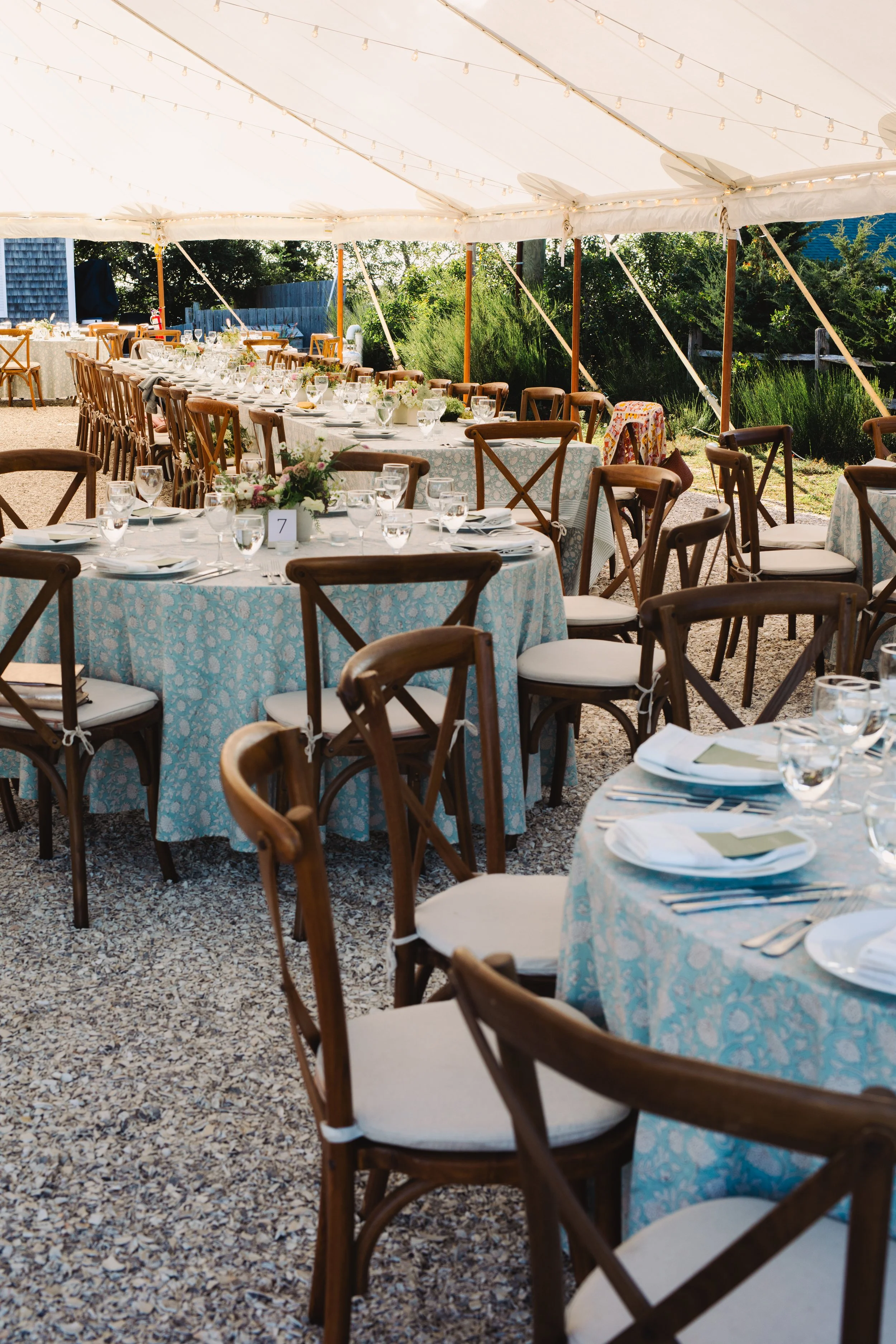 The wedding venue is decorated a ready for guests. Tables are set under the tent.