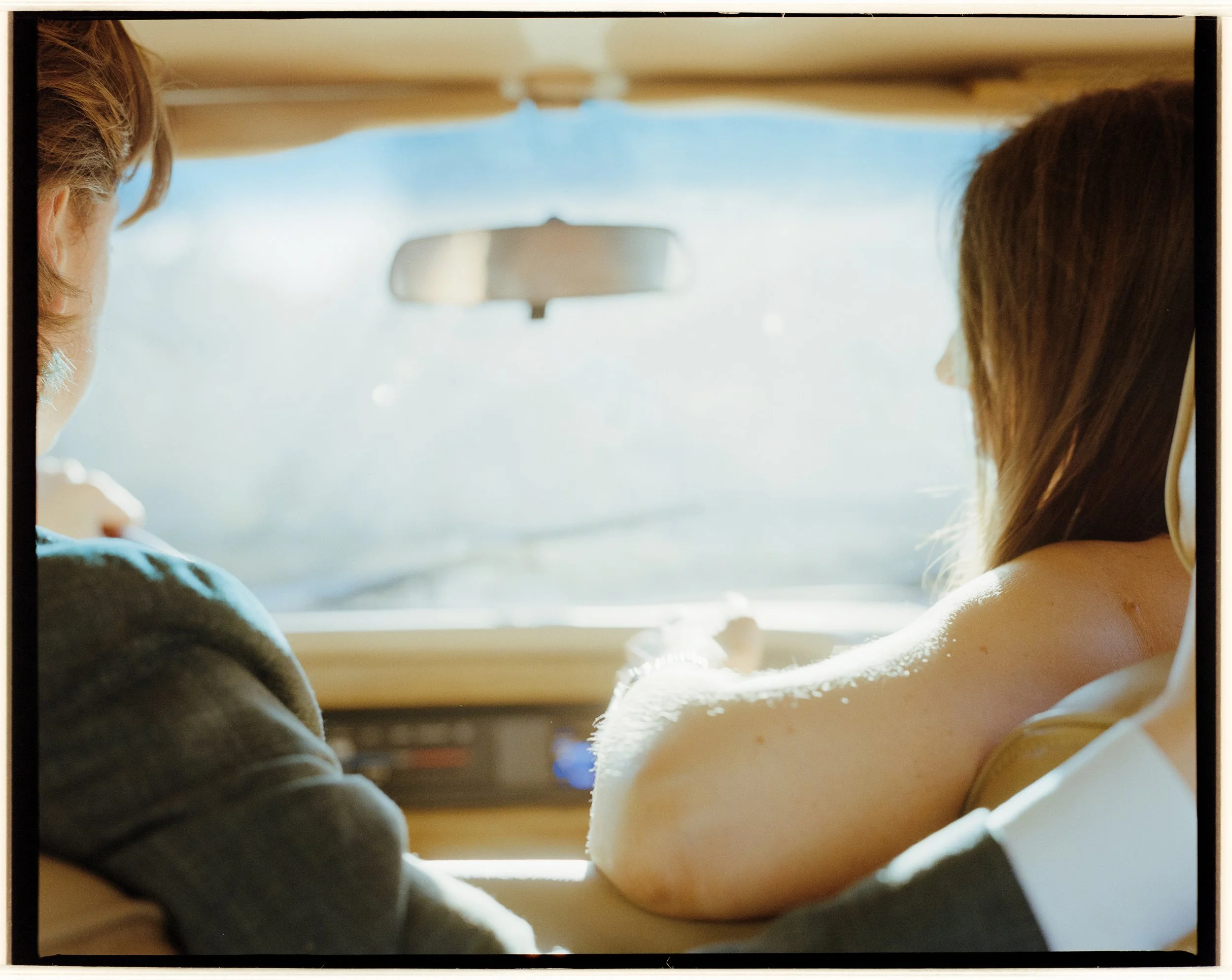 Emily and Patrick are driving away in their Jeep Wagoneer in their wedding garb.