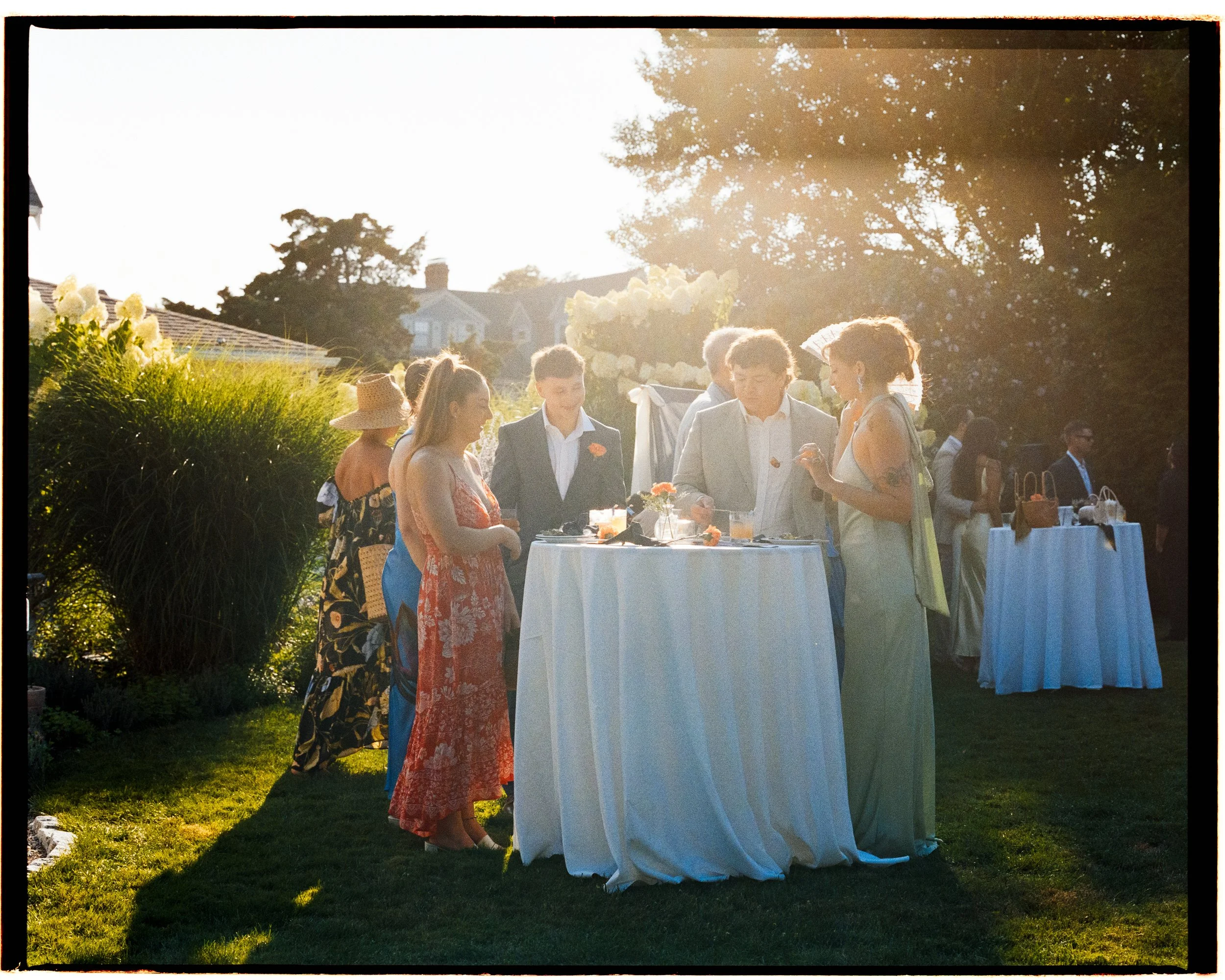 Guests surround a cocktail table in the even during cocktail hour.