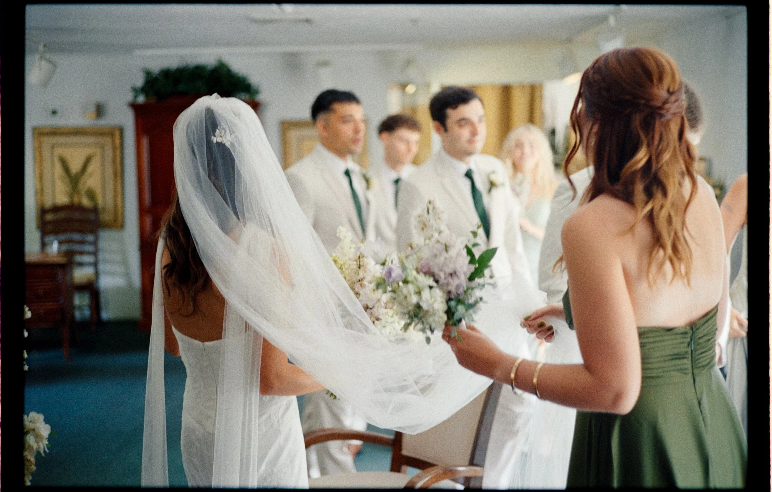 The Bride is all ready as bridesmaids and groomsmen are gather around her.