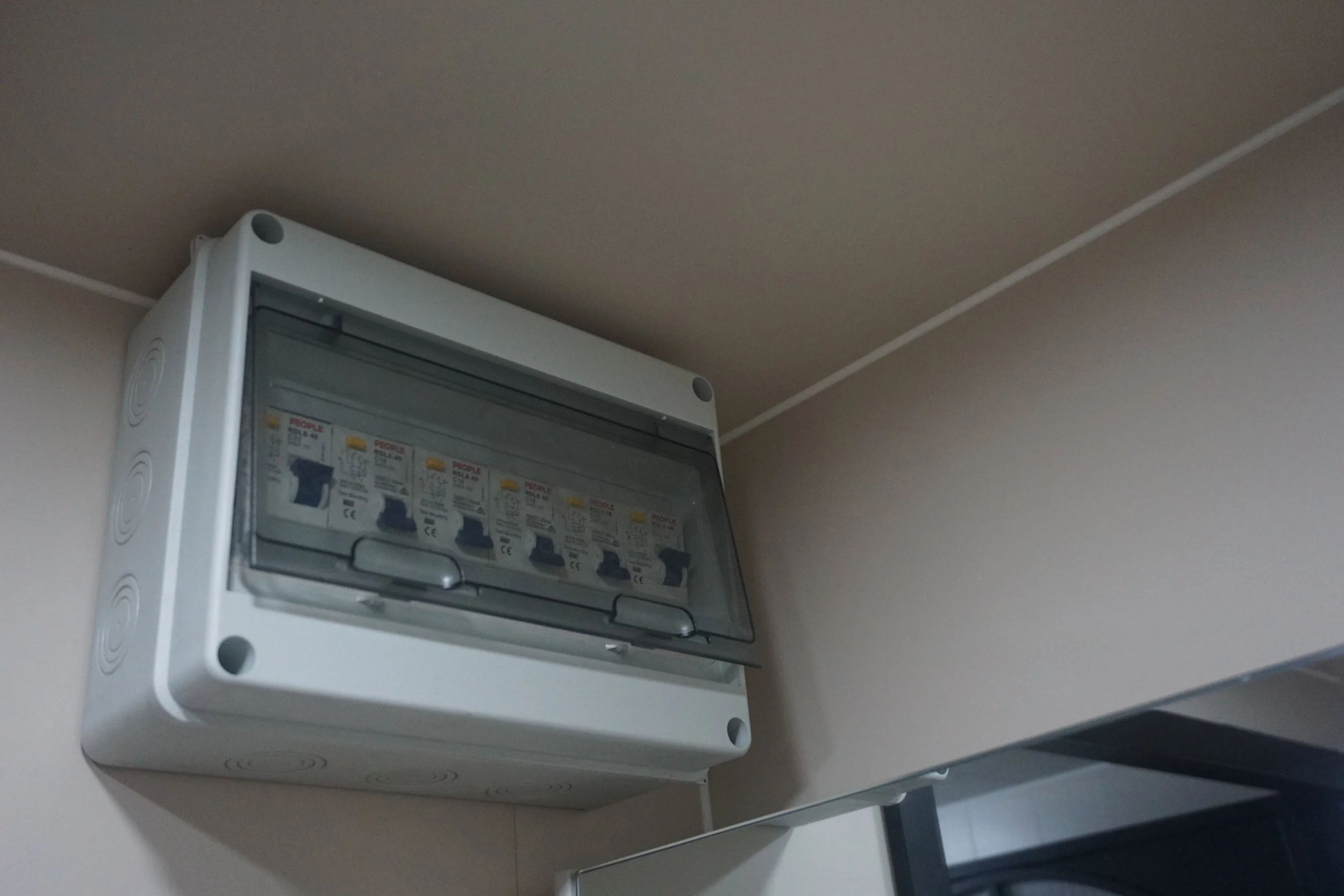 Electrical breaker box mounted on the wall in a room with beige walls and a white ceiling.