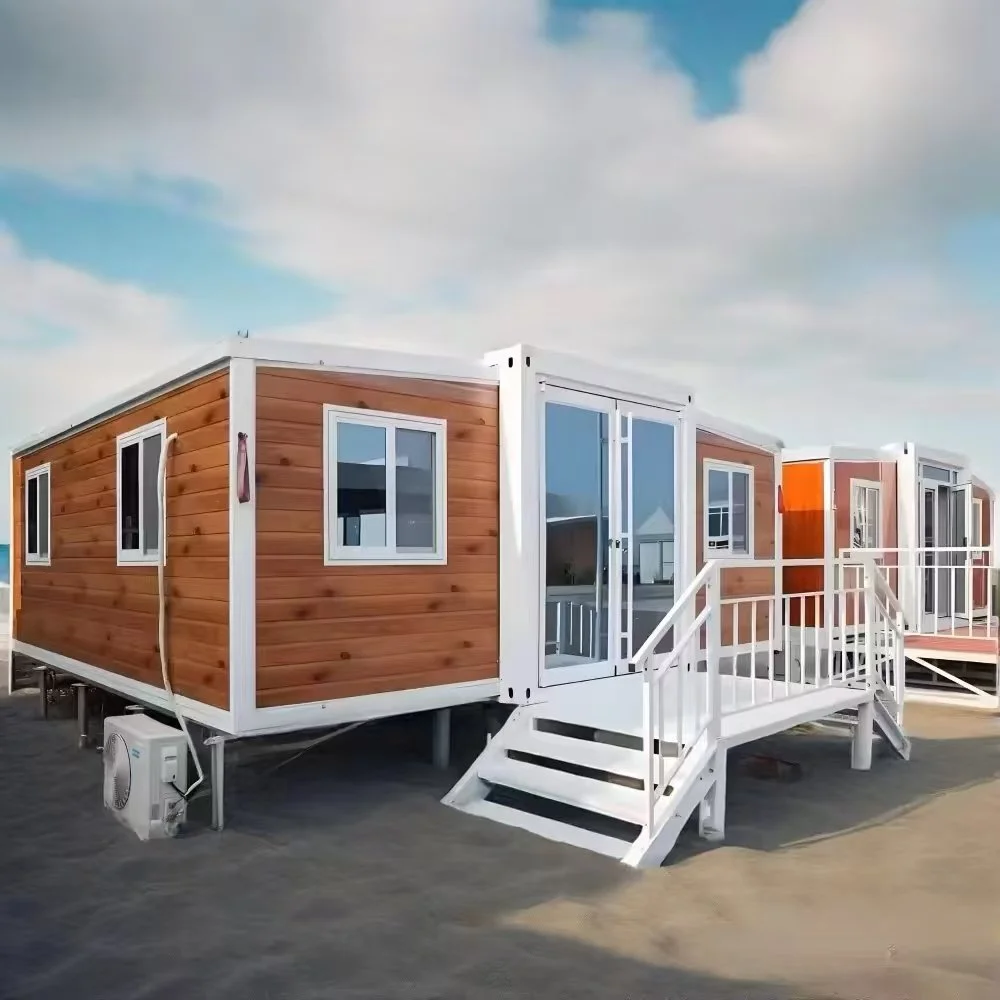 A row of tiny mobile homes with wooden siding and white trim, elevated on stilts with white stairs leading up to the doors, set against a partly cloudy sky.