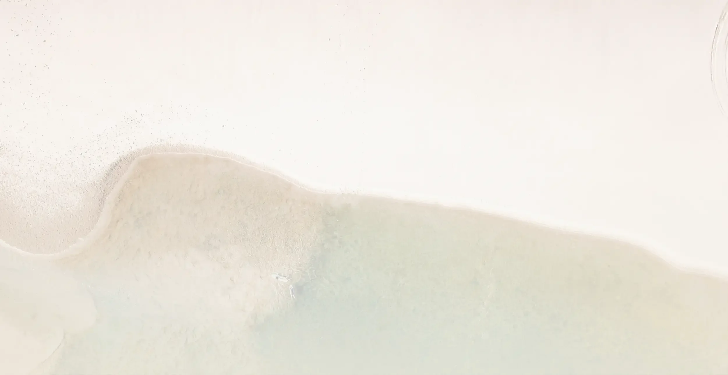 Close-up of a white surface with a smooth, curved indentation or pattern in the lower left corner.