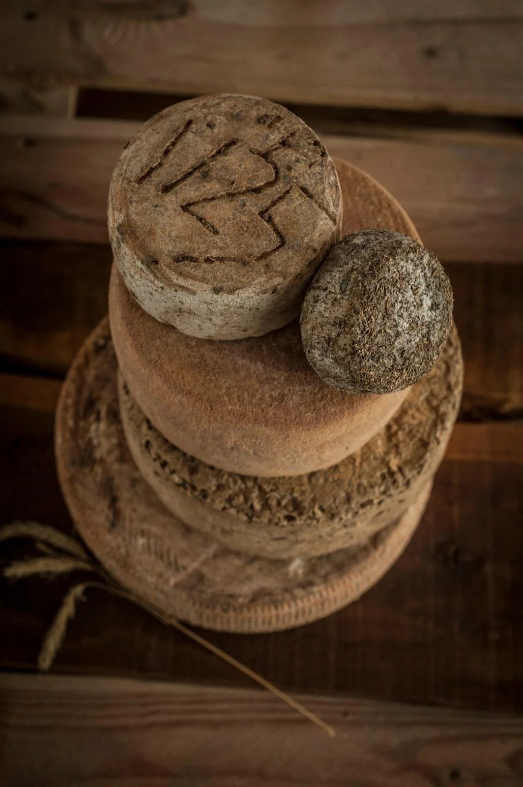 Trois pierres empilées, la plus grande en bas, une moyenne au milieu et une petite en haut, posées sur une surface en bois.