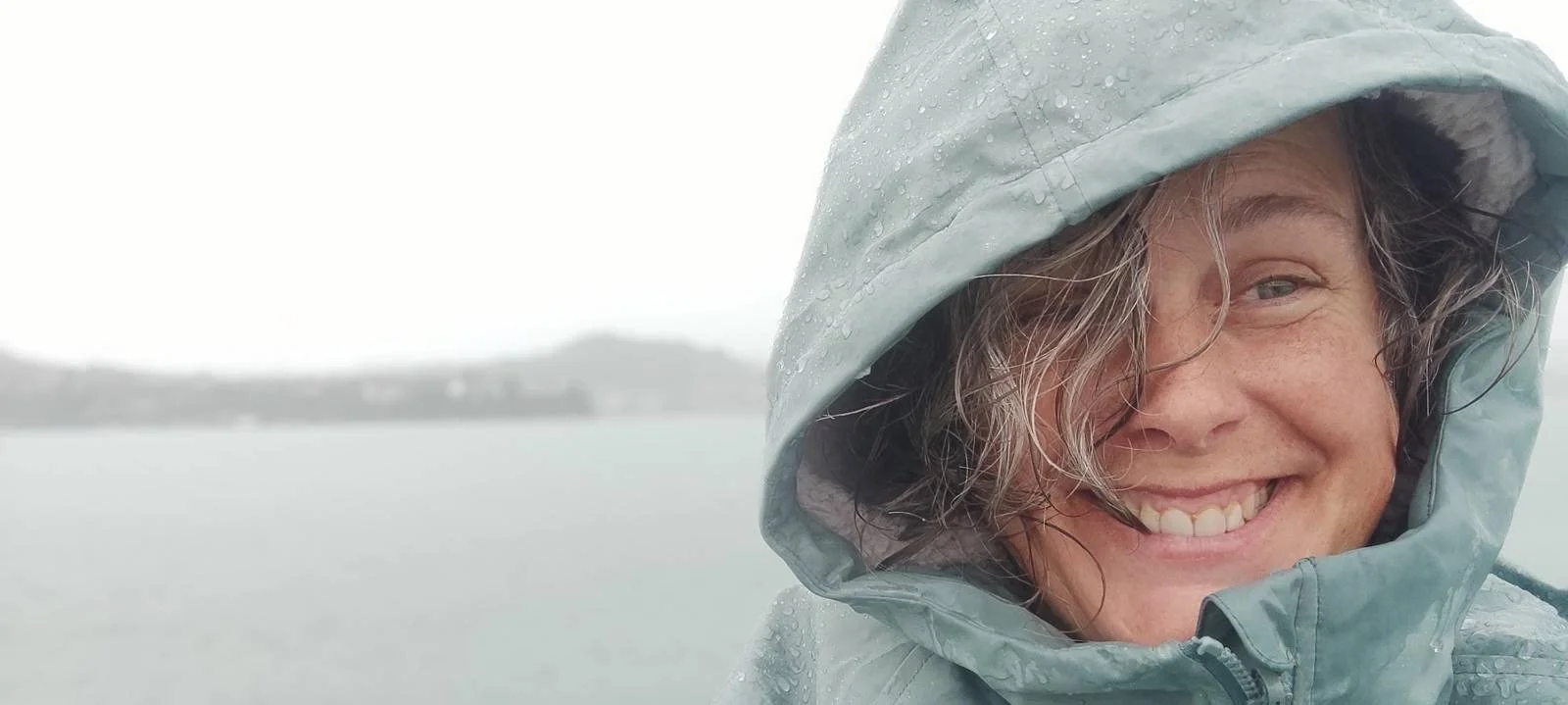 Close-up of a woman with long, curly hair smiling at the camera