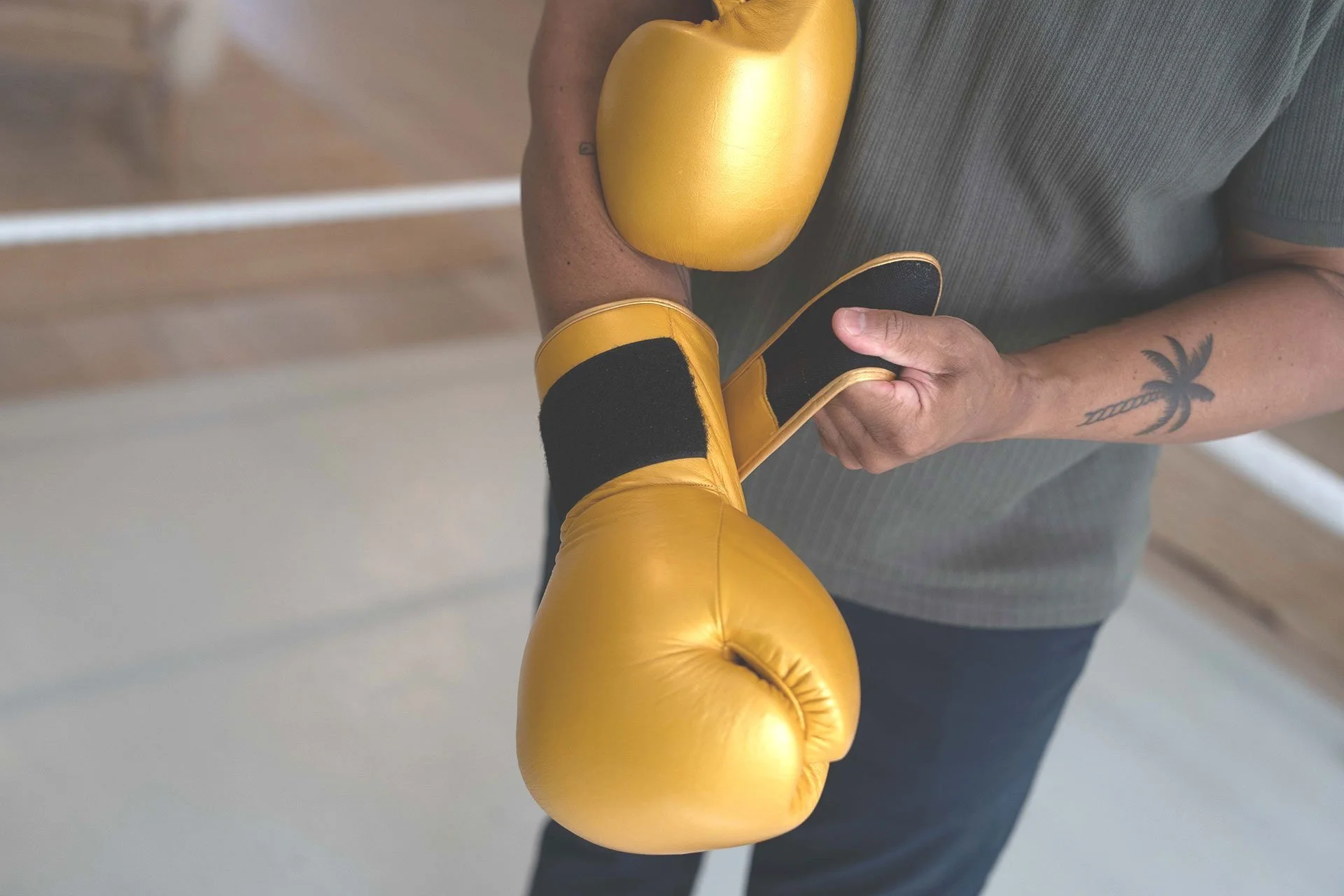Person wearing yellow boxing gloves holding a yellow punching mitt.
