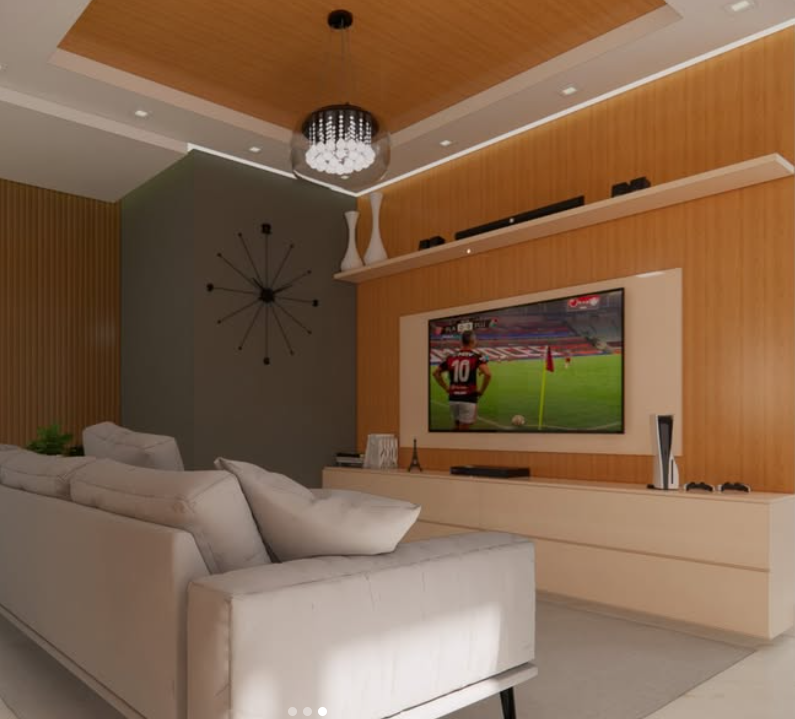 Sala de estar moderna com sofá branco, televisão exibindo jogo de futebol, decoração com vaso e relógio de parede, iluminação embutida no teto e móveis de madeira