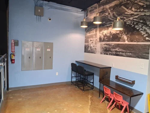 Comfortable seating area with historic Hurst mural at Texas Tumble Wash
