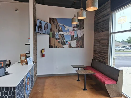 Waiting area with TV and bench seating at Texas Tumble Wash Hurst TX