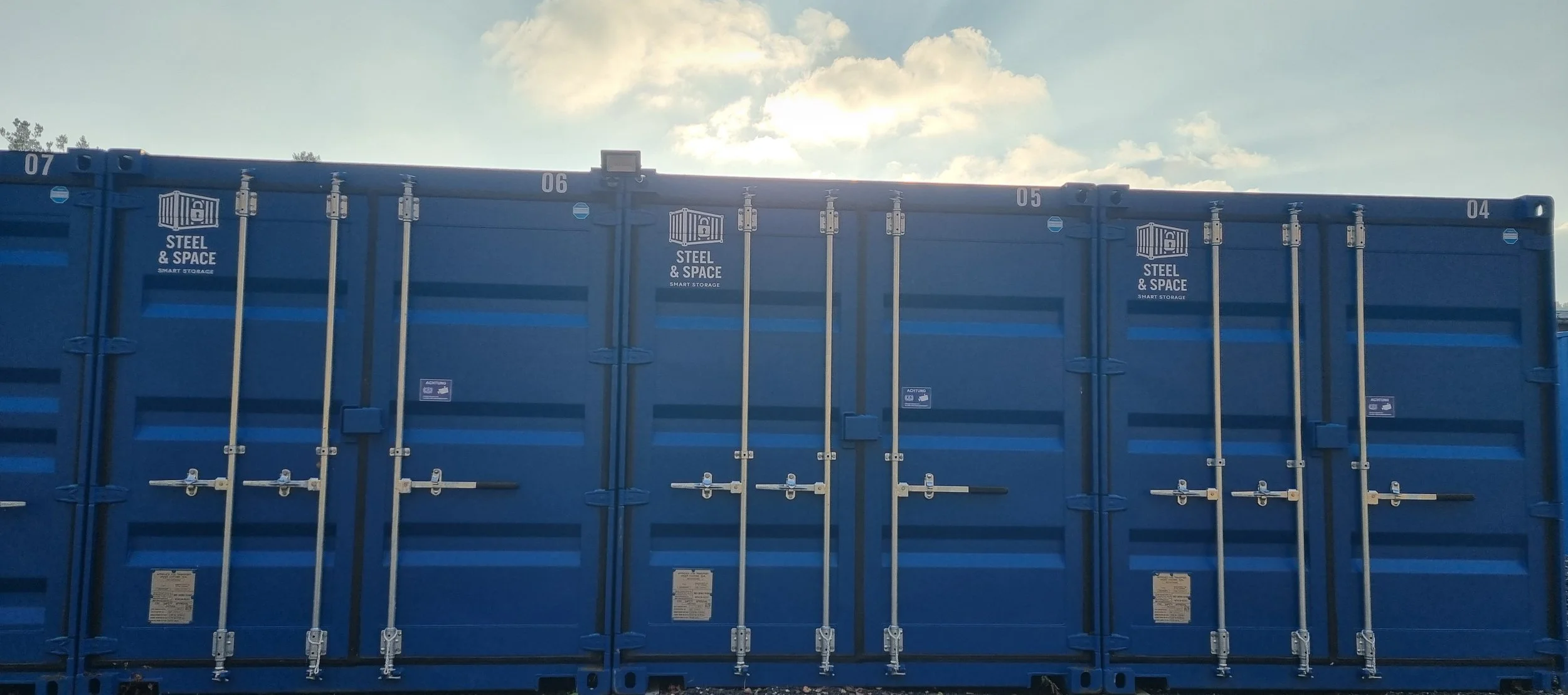 A large blue storage container with metal locks and hinges, labeled 'Steel & Space Smart Storage' on the upper left and middle sections.