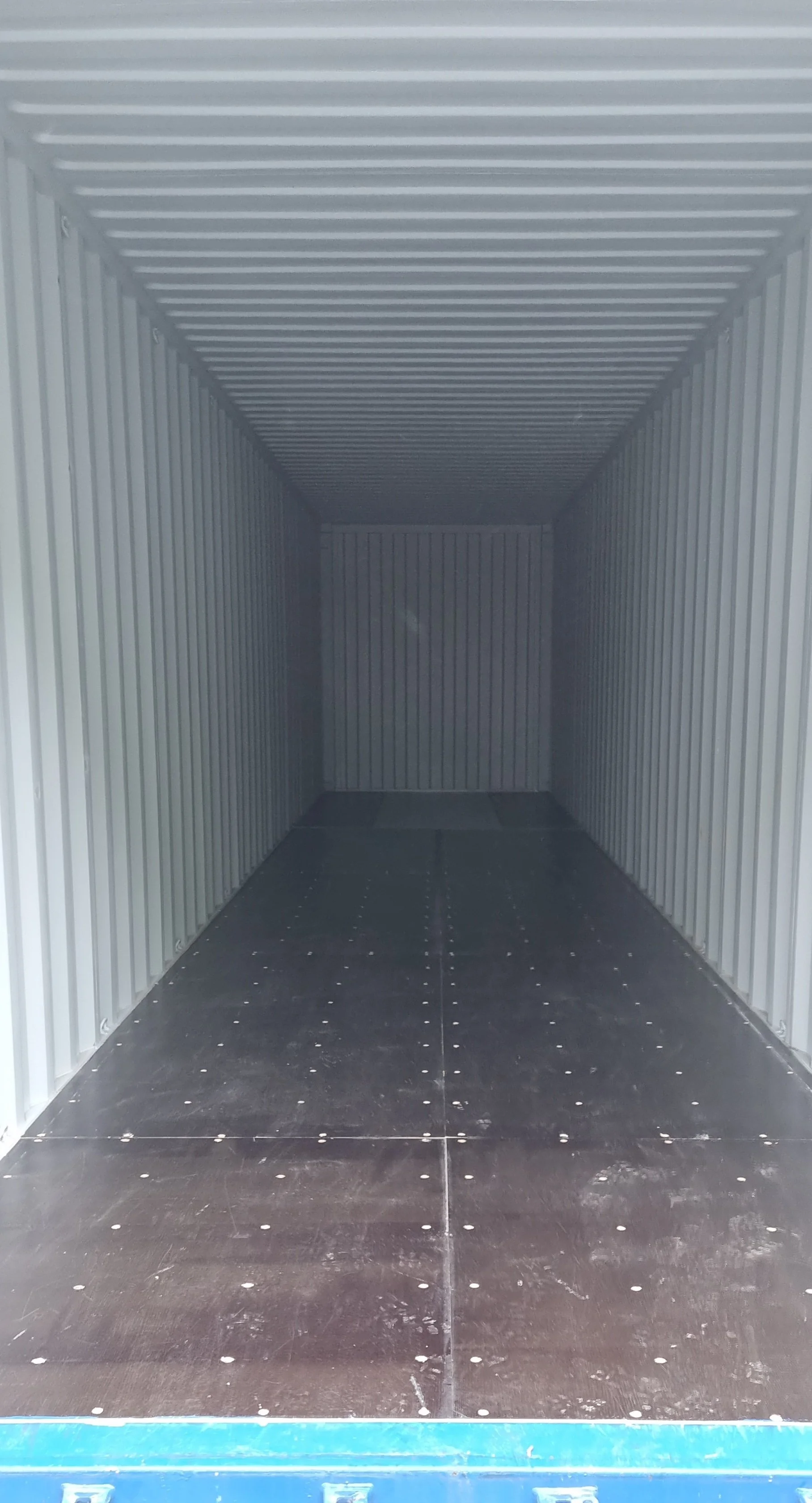 Empty metal storage container with gray walls and black floor.