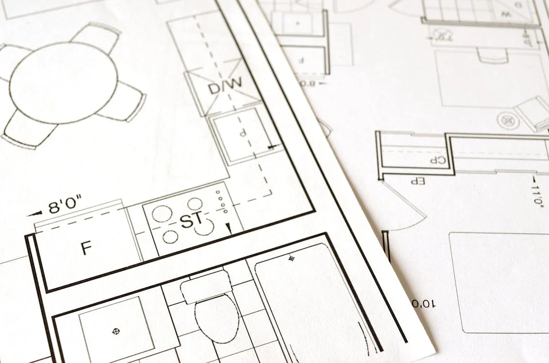 Close-up of architectural blueprints showing room layouts, fixtures, and measurements for a building design.