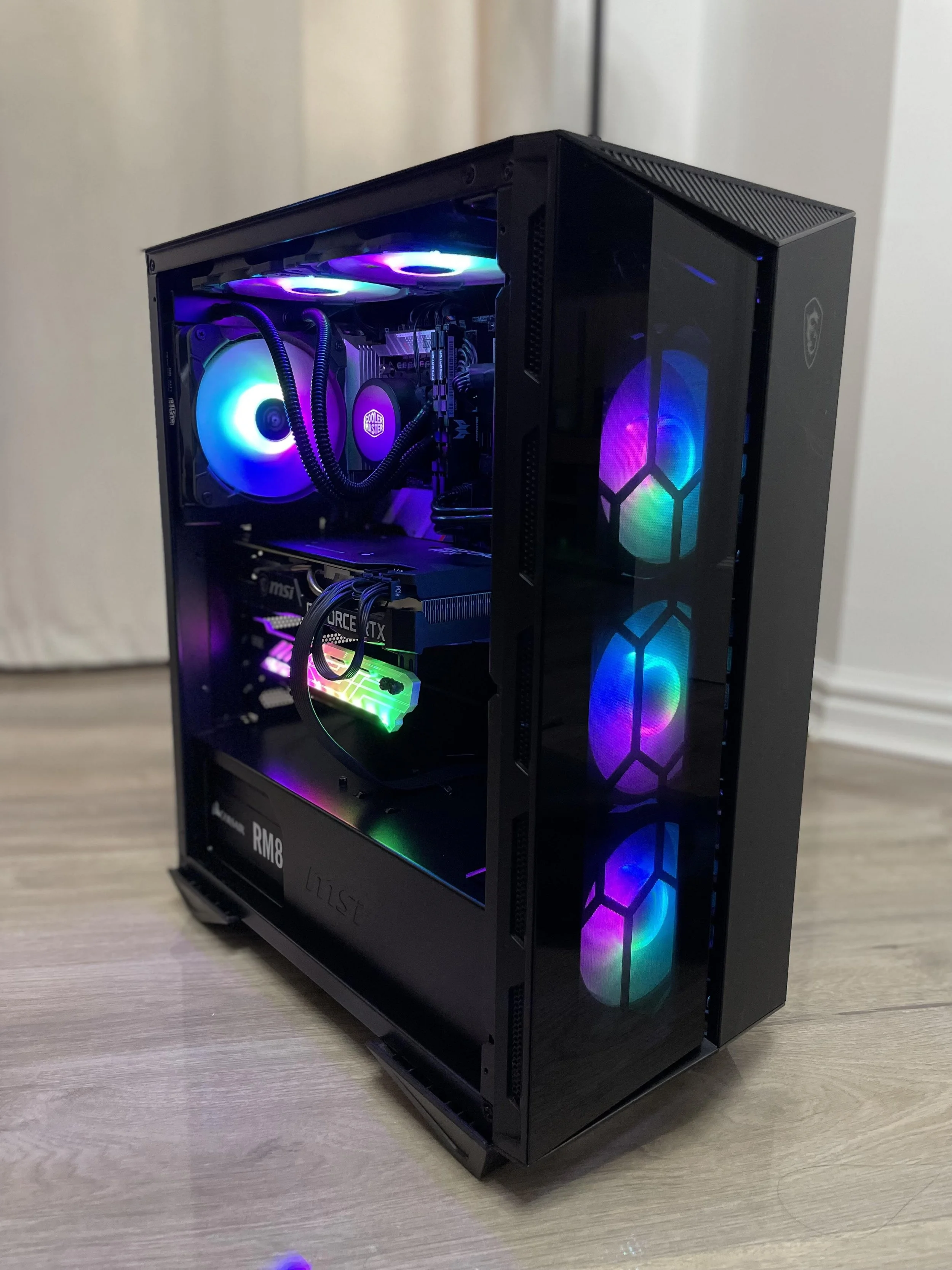 A gaming desktop computer with RGB fans and components visible through a glass side panel.