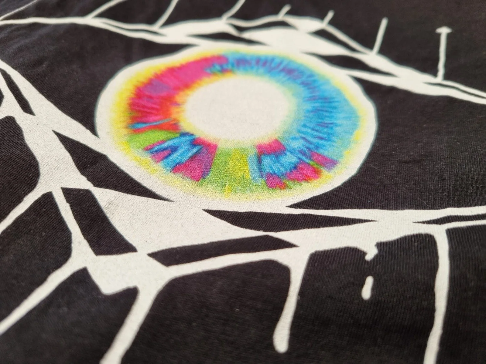 Macro image of the Pastel Eye design printed on black organic cotton.