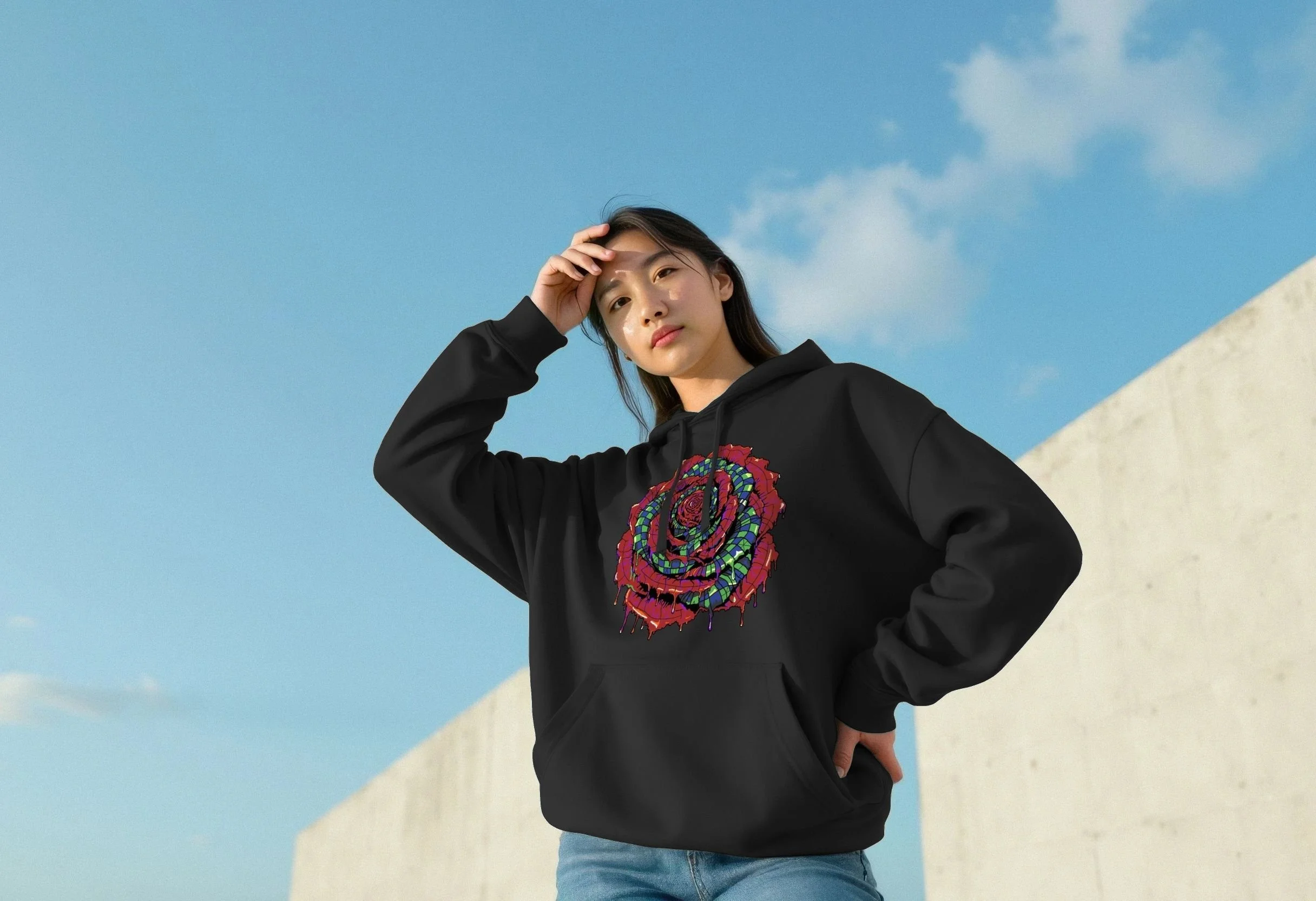 Woman wearing the black Synaesthesia organic cotton hoodie by Mongrel Logic, featuring a large red, green, blue and purple spiral flower design with dripping details.