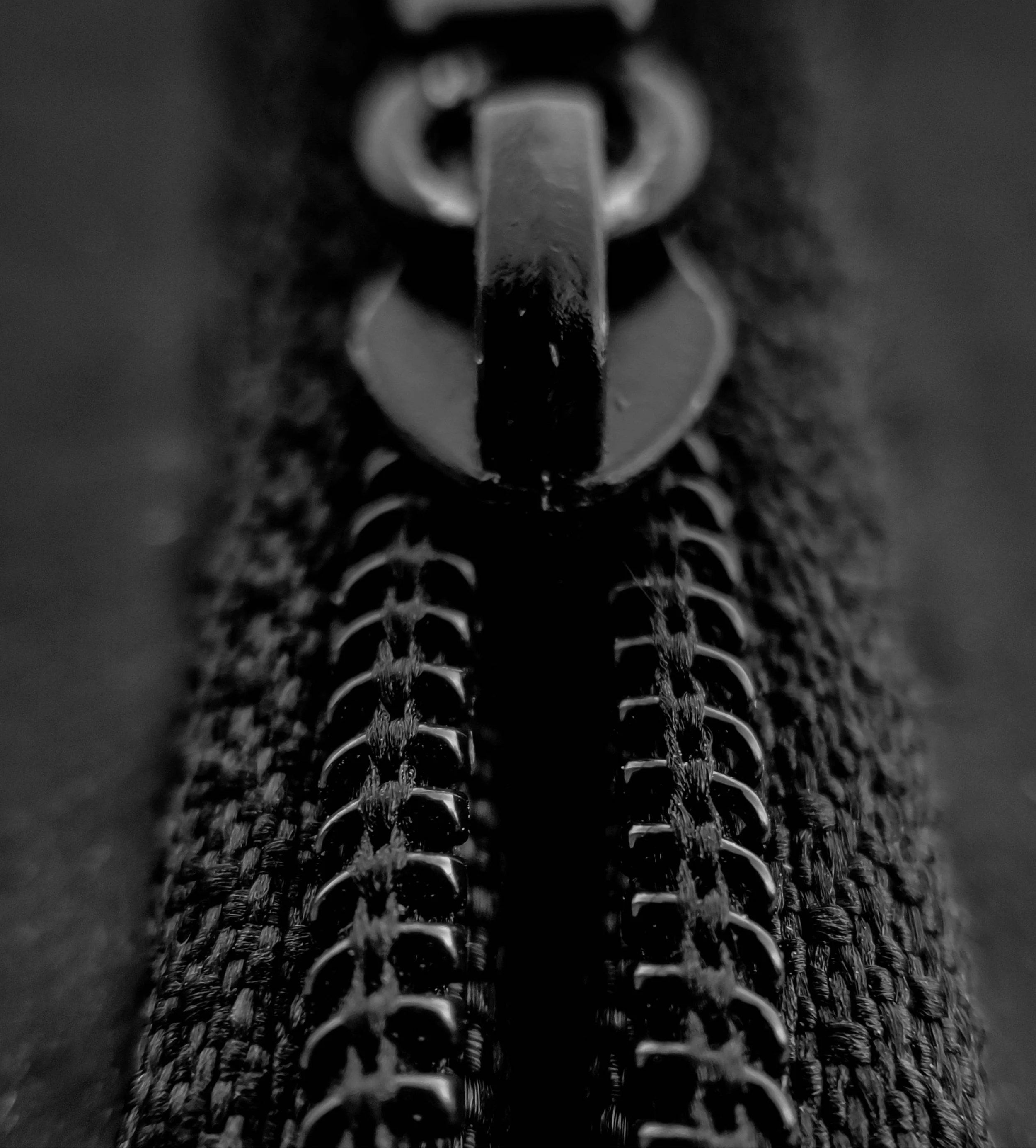 Close up photo of a zip, showing macro detail of fabric density and zipper.