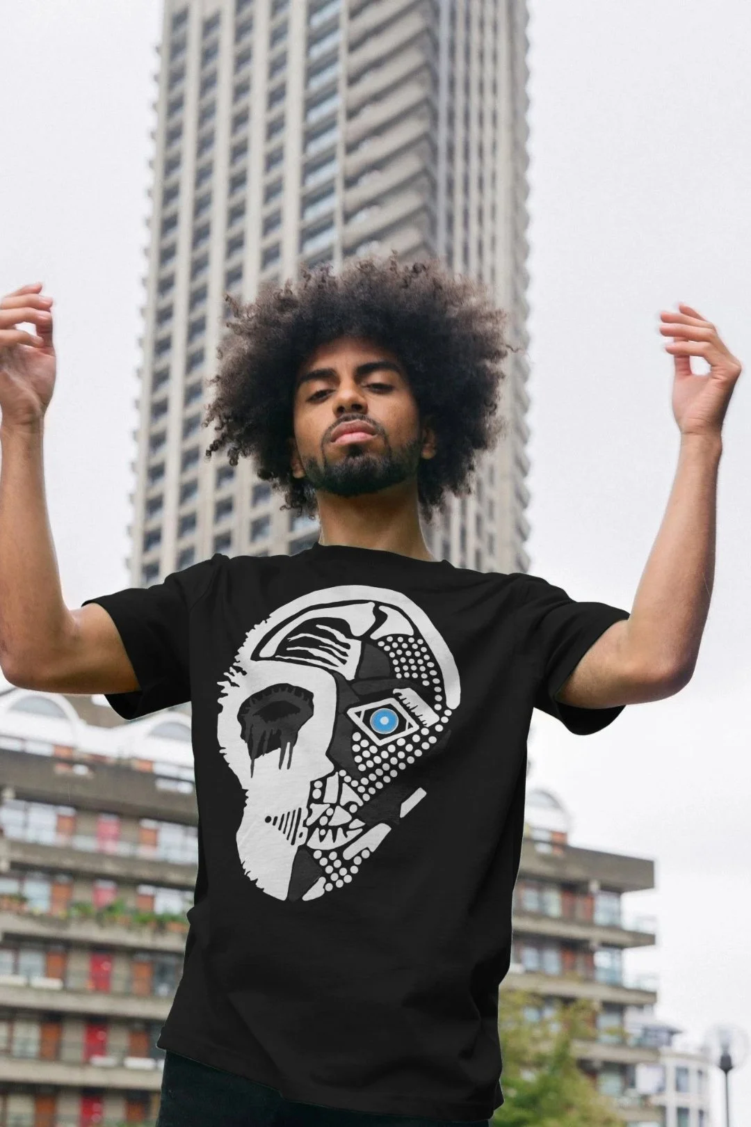 Model wearing the Tenet II by Mongrel Logic in Black. Featuring a black and white geometric split faced graphic with a single-coloured eye.