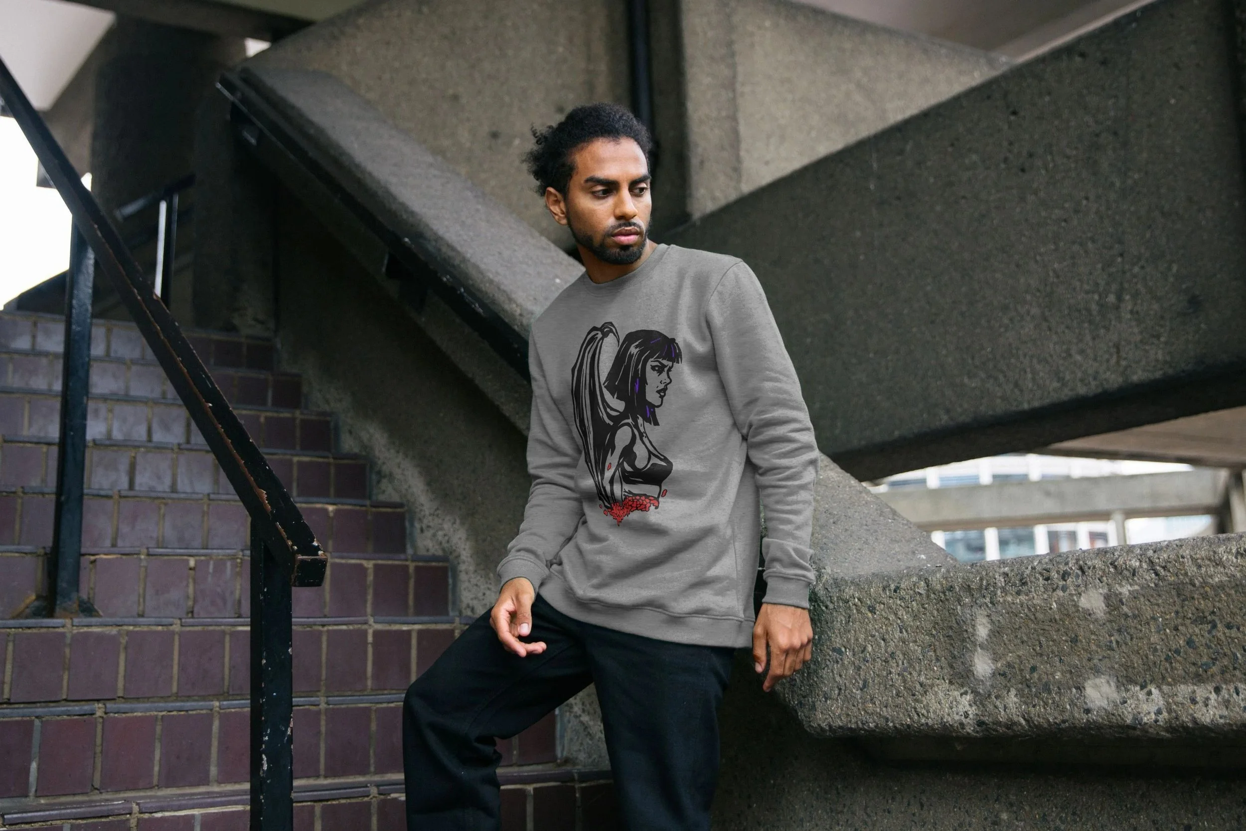 Model wearing the grey Logic Watches organic cotton sweatshirt by Mongrel Logic, featuring a black illustrated portrait of Logic with wings and red floral details.