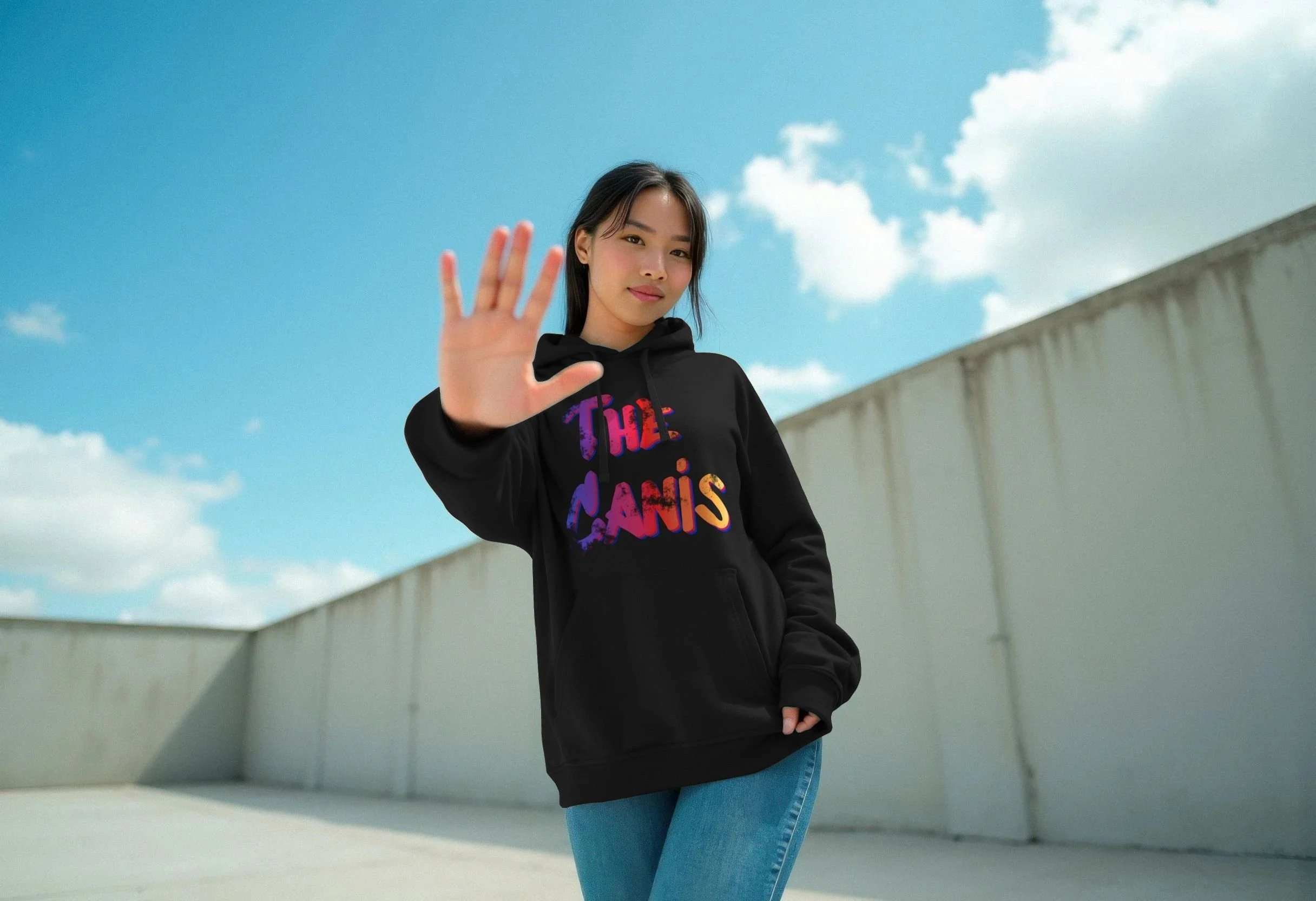 Woman wearing the black The Canis organic cotton hoodie by Mongrel Logic, featuring the colourful hand-drawn The Canis logo across the chest.