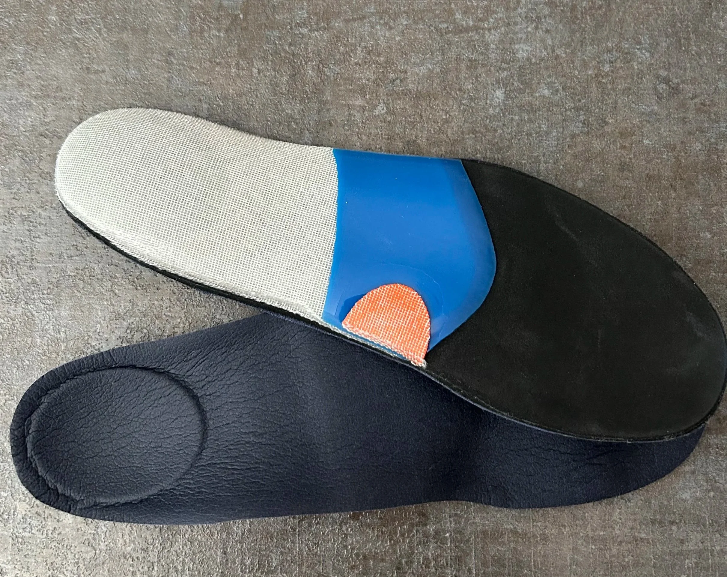 Paire de semelles posturales sur mesure avec différents éléments de stimulation plantaire.