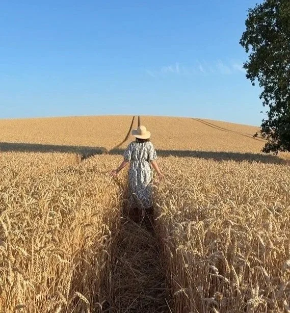 Sarah Hudson, IBS hypnotherapist, walking in wheat field