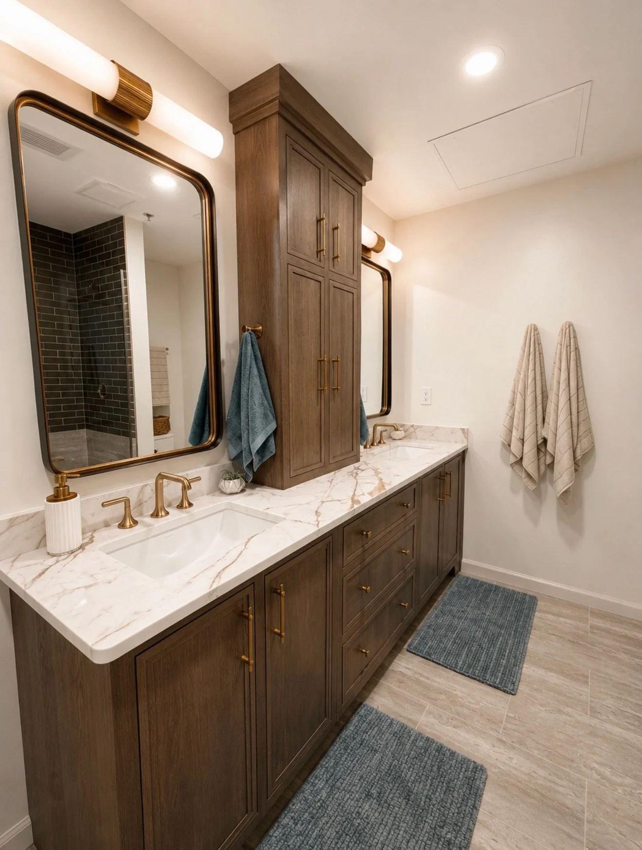 From builder-basic to bold and elevated.

This bathroom transformation completely changed the feel of the space &mdash; rich wood cabinetry, warm brass accents, dramatic mirrors, and a custom storage tower brought depth, function, and a boutique hote