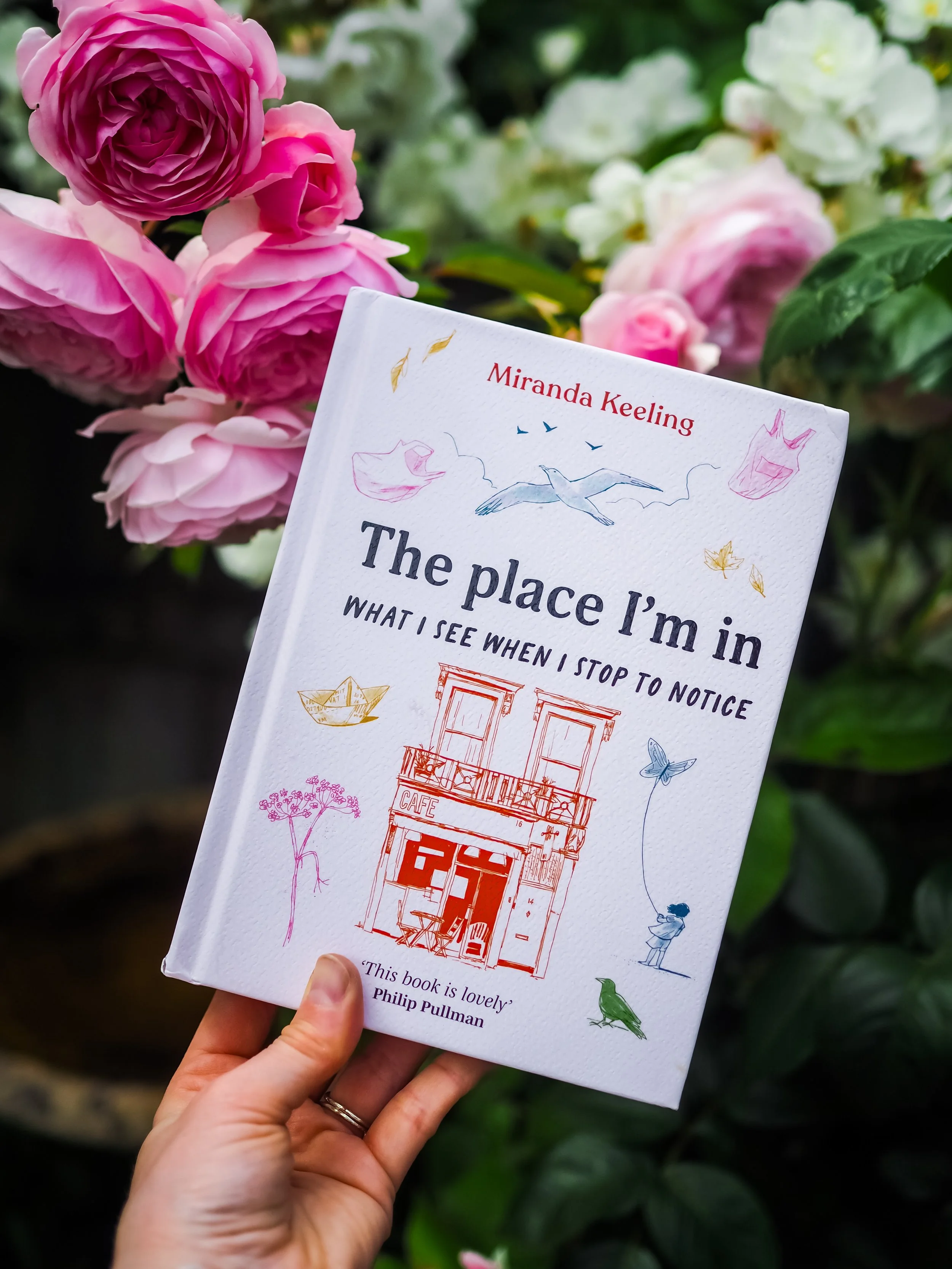 A woman holding a copy of The Place I'm In by Miranda Keeling