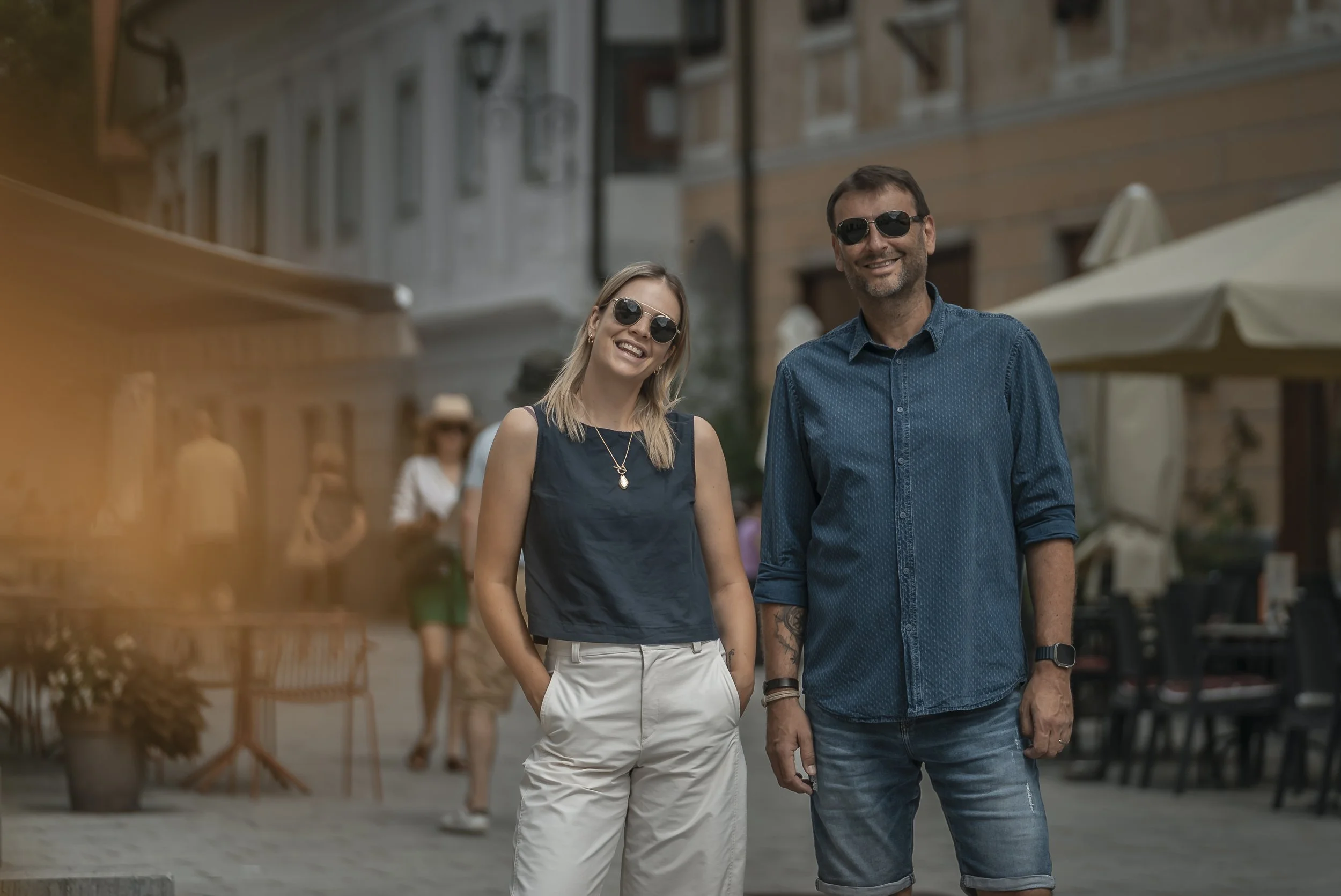 A smiling male and female tour guide standing in a central European town