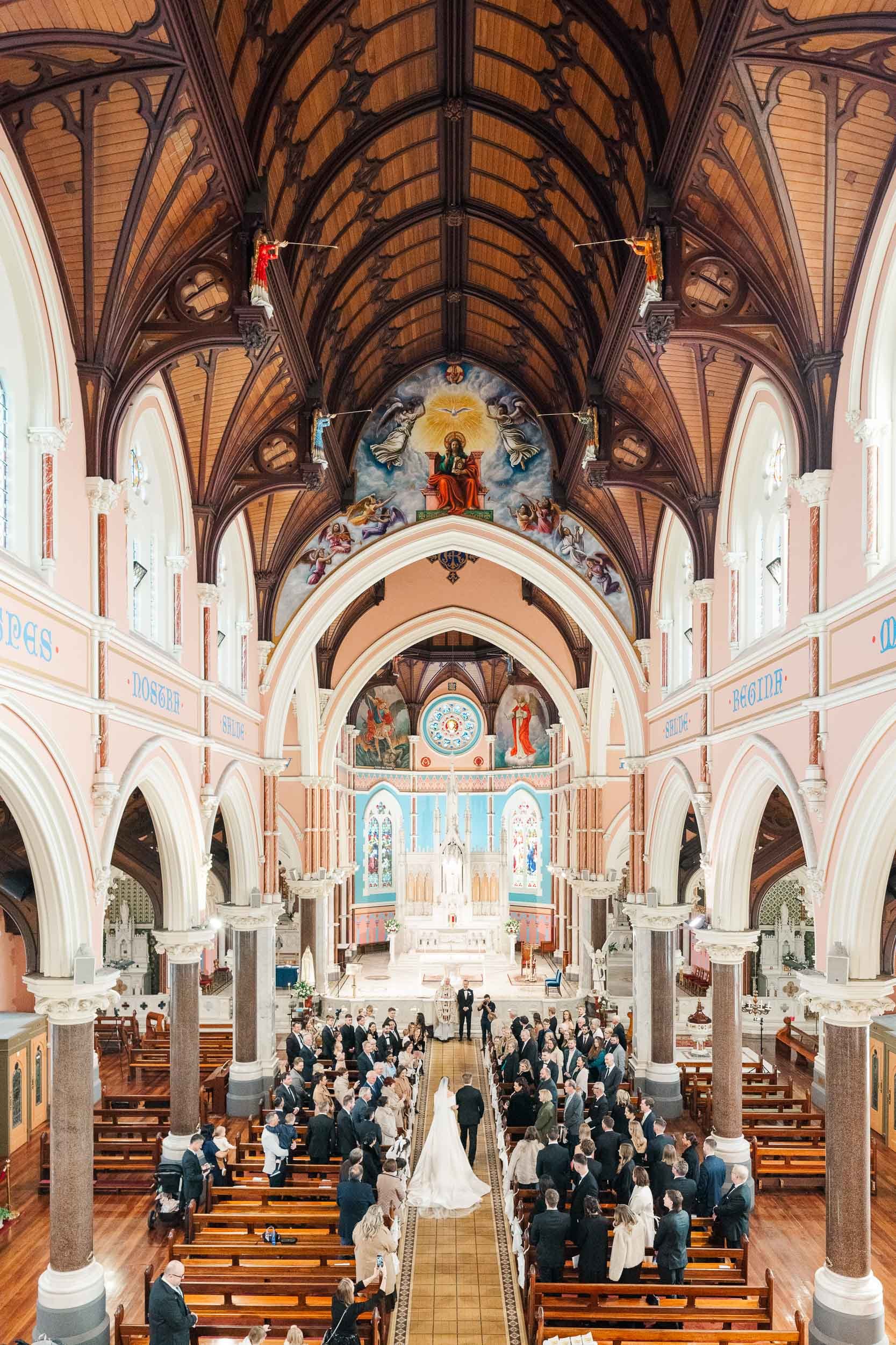 Bride walking down the aisle with her father to the groom, among stunning architecture, photographed by wedding photographer Sherman Tan Studio
