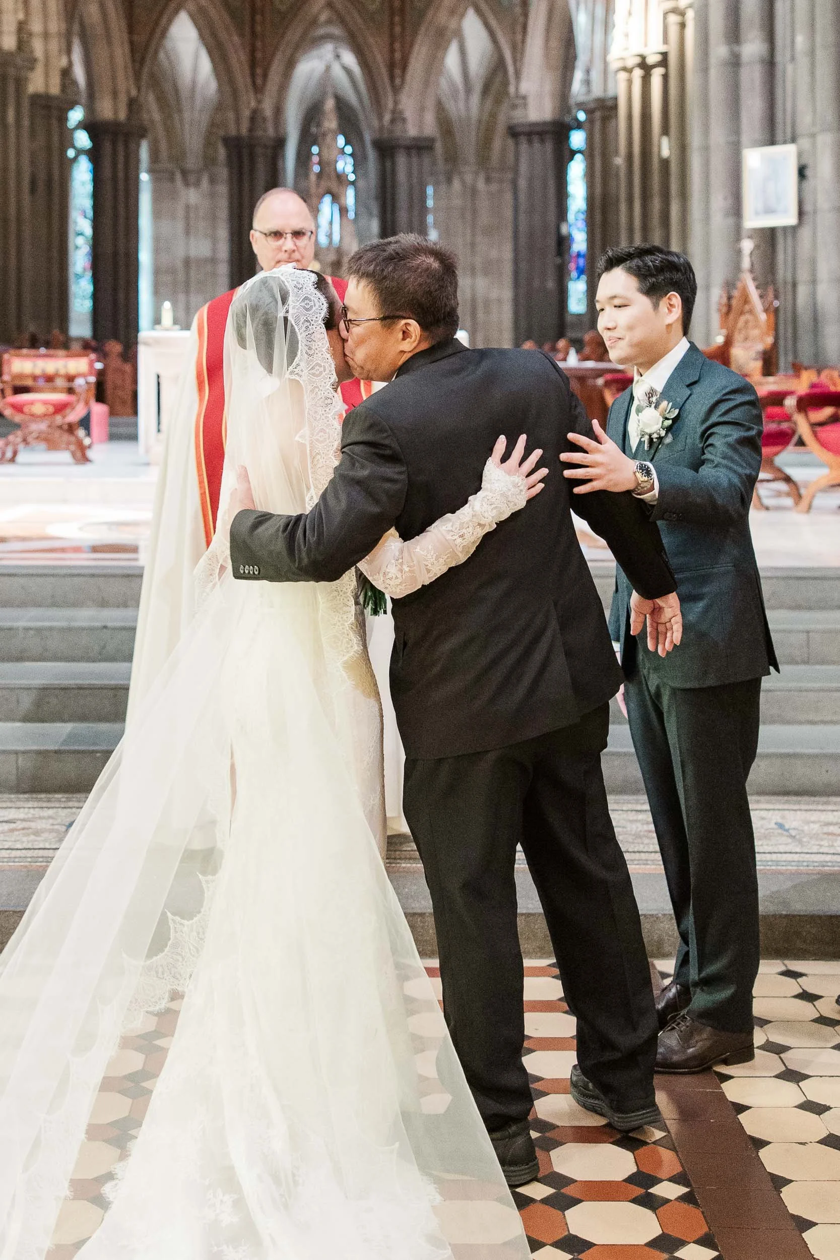 Emotional moment at St Patrick's Cathedral as a father kissing her daughter as he hands her over to her future husband, beautifully captured by the best wedding photographer Sherman Tan Studio