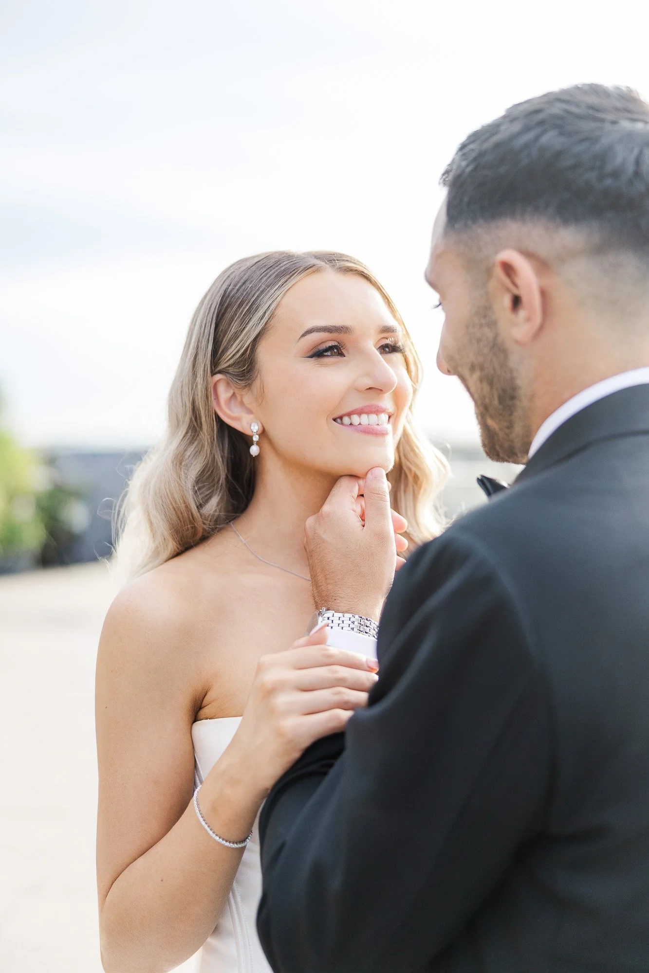Elegant Melbourne Wedding Photography of a groom holding to the bride's face as they look at each other lovingly.