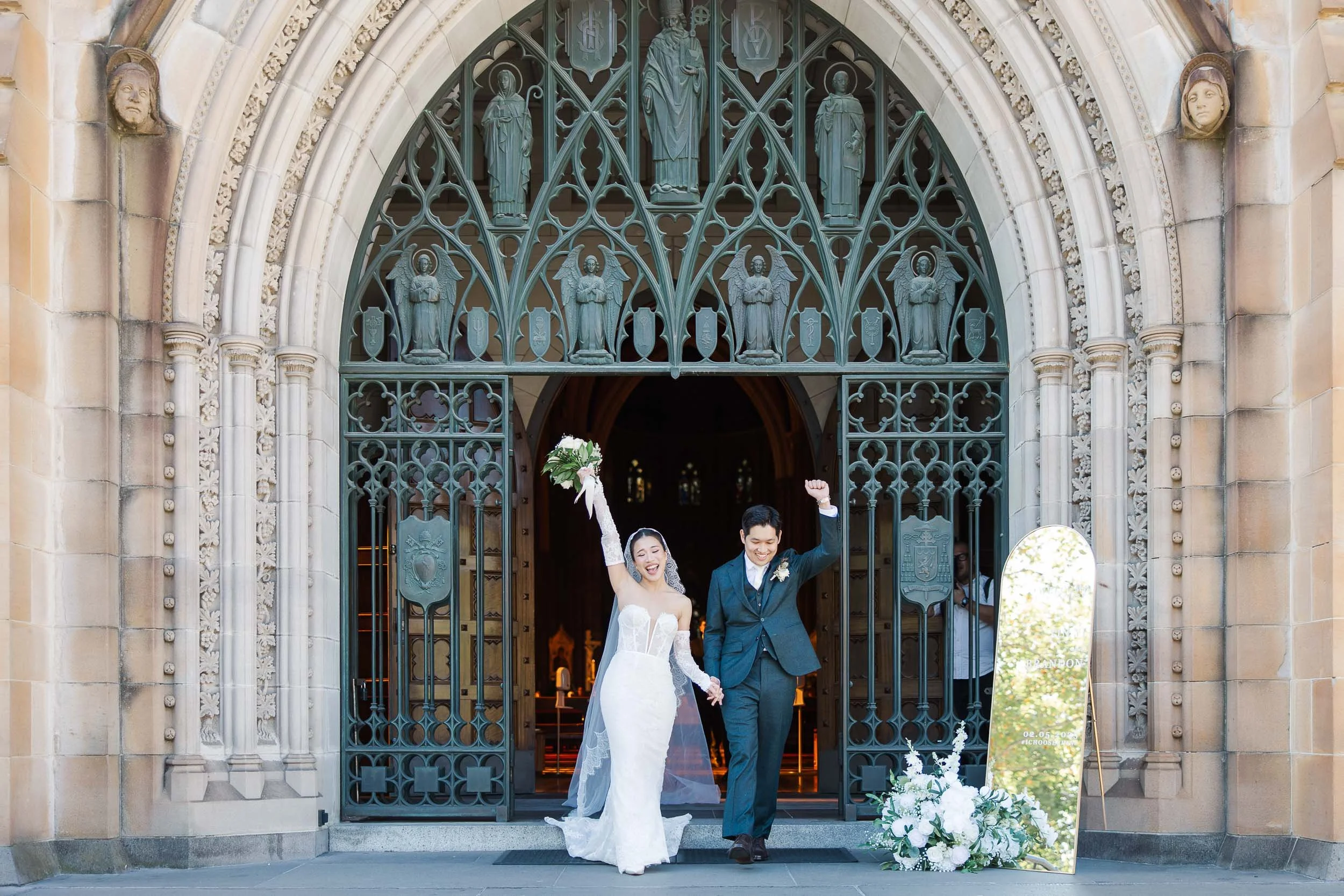 Couple exiting with joy from St Patrick's Cathedral after their wedding ceremony photographed by Melbourne's best wedding photographer Sherman Tan Studio