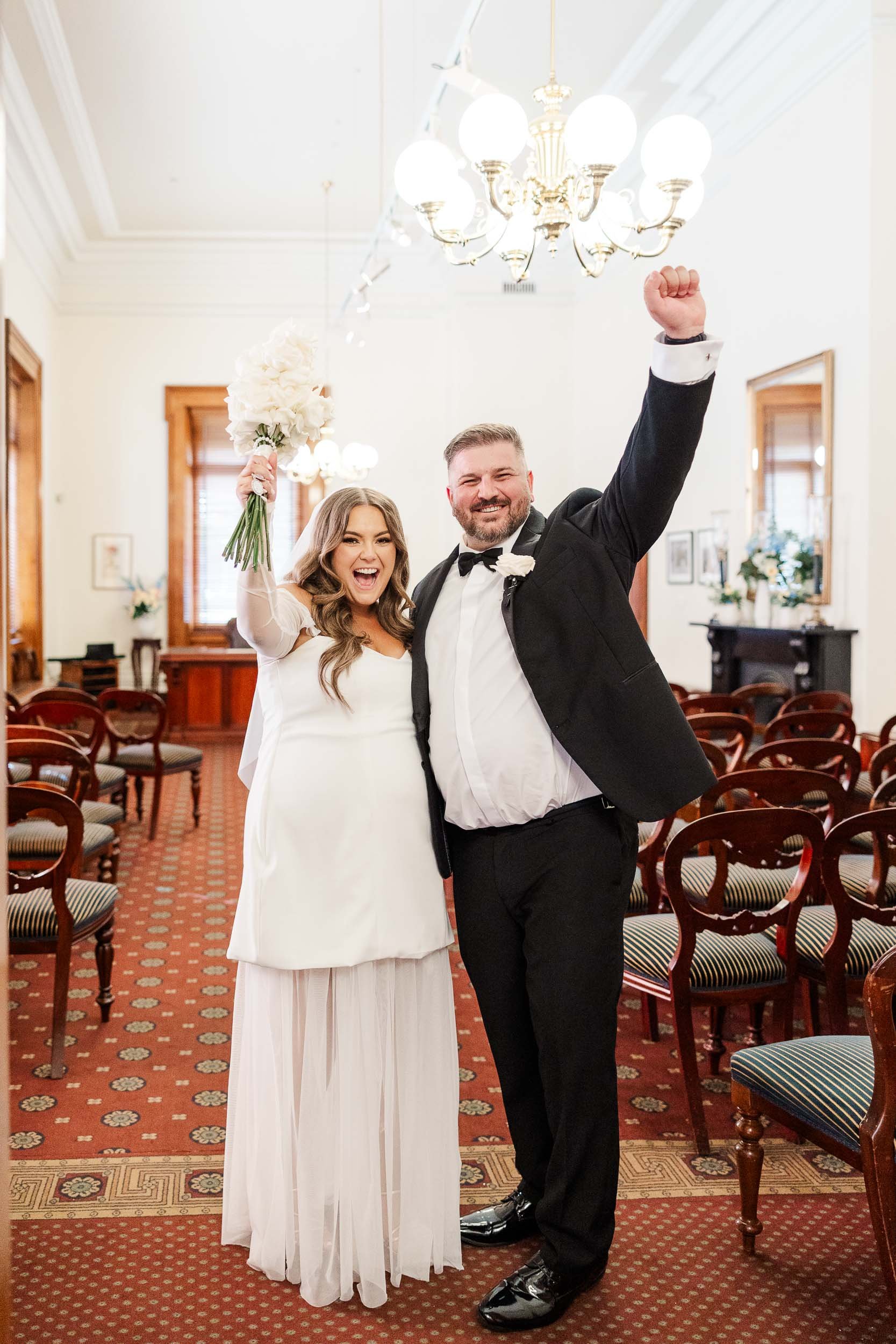 Melbourne Civil Registry Wedding Old Treasury Building portrait of a joyful newlywed couple celebrating inside the elegant ceremony room.