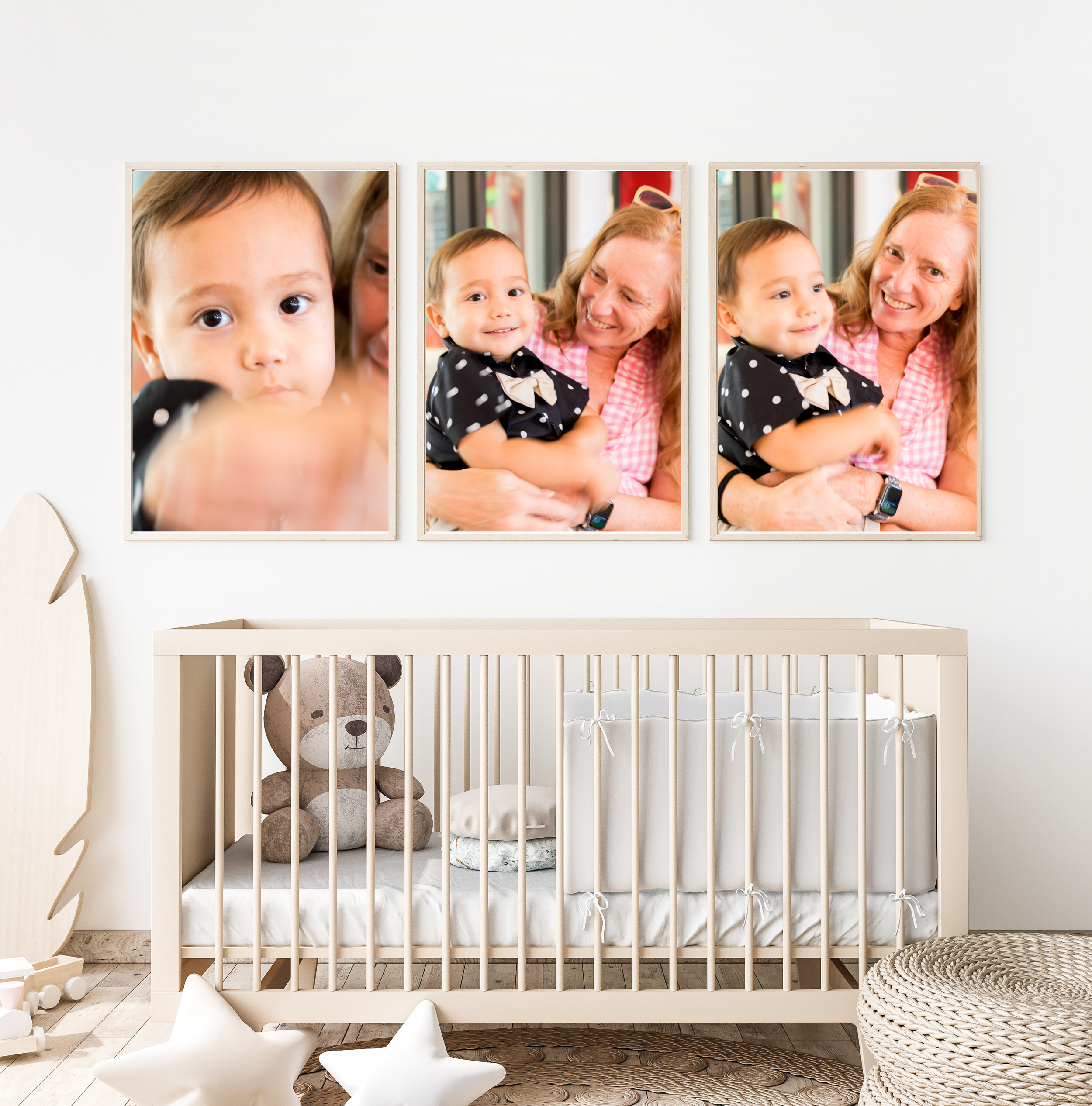 Nursery room with three framed photos of a young child and an older woman on the wall above a crib, which contains a stuffed bear, a pillow, and a changing pad, with star-shaped cushions and a woven basket nearby.