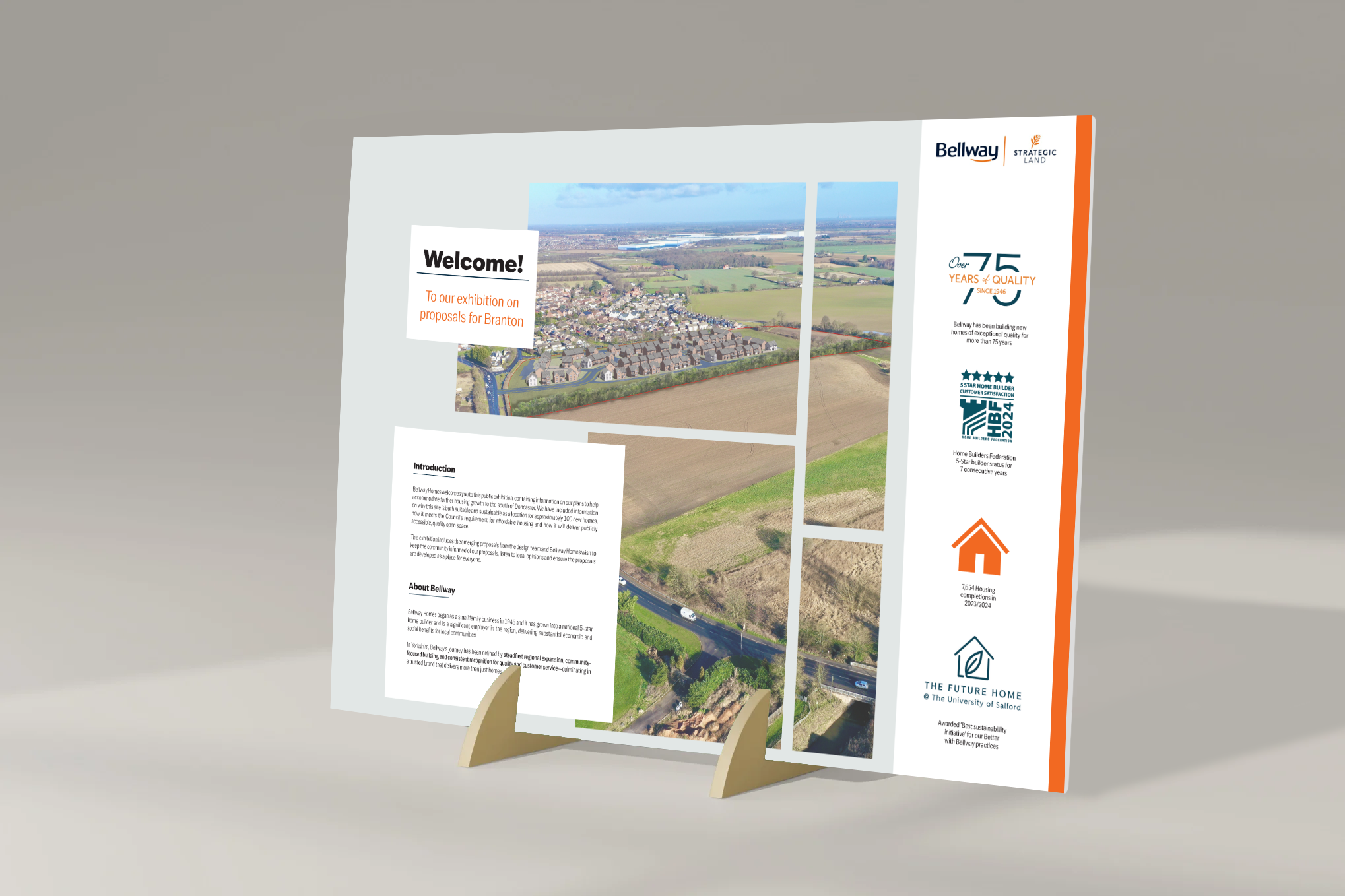 Information board featuring aerial images of a residential area, logos, and text about a housing exhibition, awards, and local community projects.