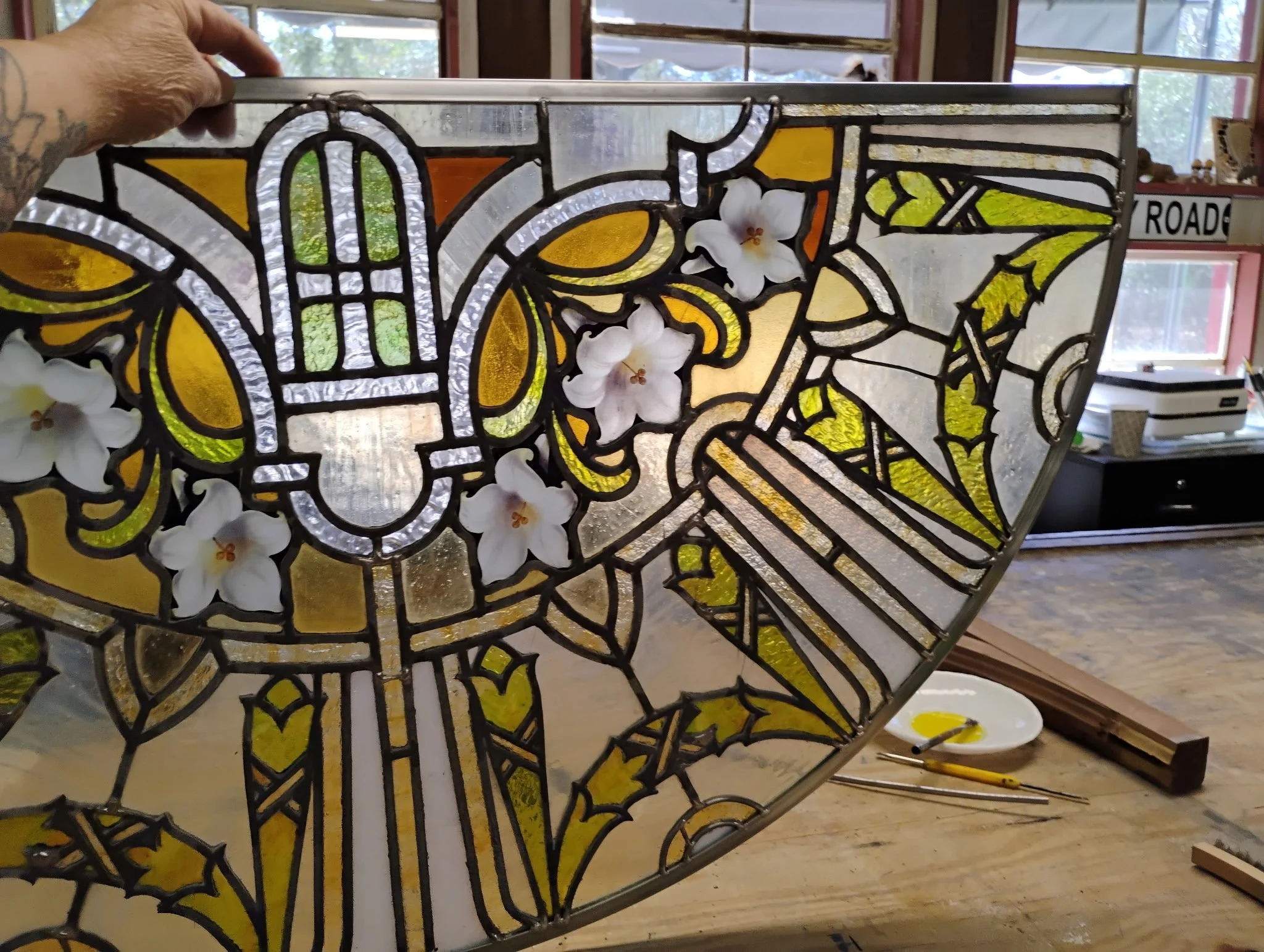 Photo of antique floral semi-circle stained glass panel after repairs have been made for a residential client