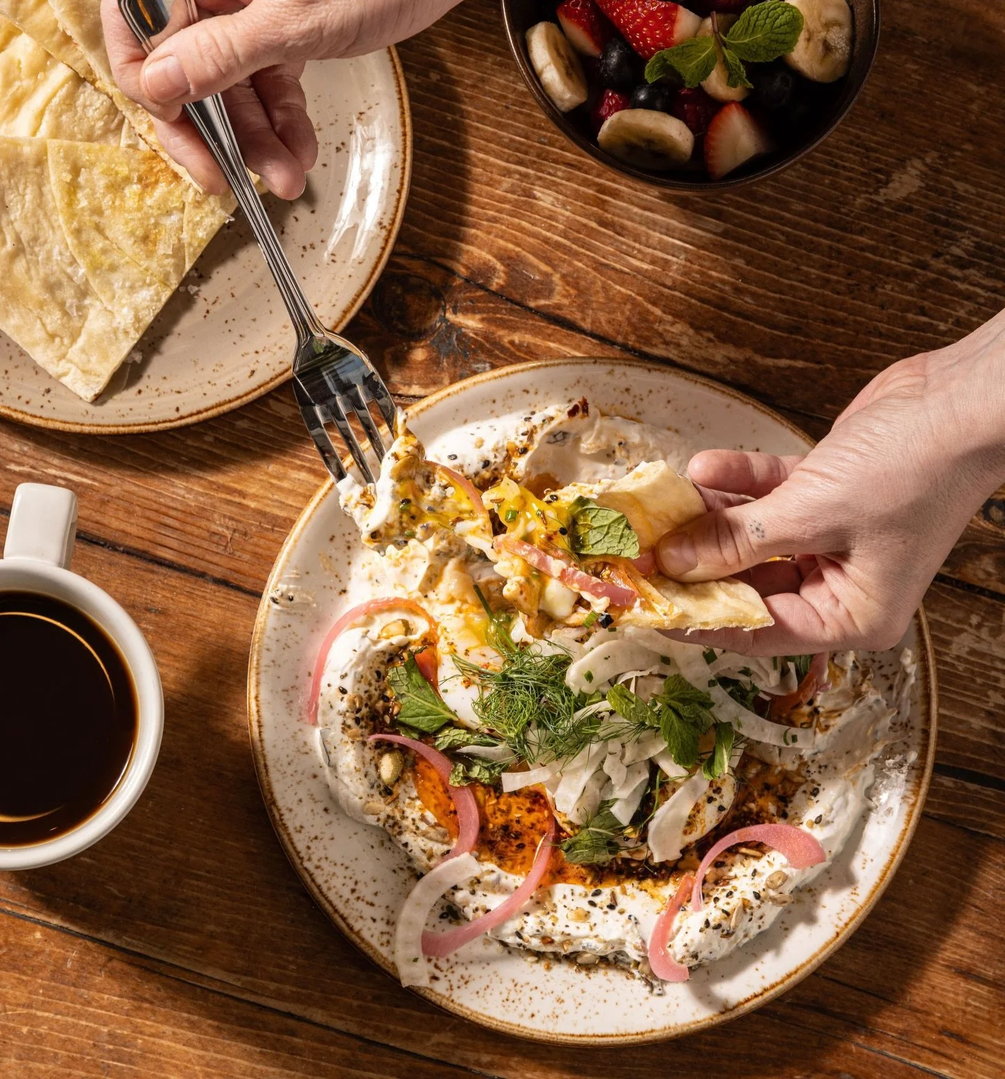 Our Turkish eggs start with poached local @highspirehillsfarm eggs, tangy garlic yogurt, spiced butter that pools into everything, crunchy dukkah, bright herbs, and freshly baked naan to bring it all together. It&rsquo;s messy, it&rsquo;s beautiful, 