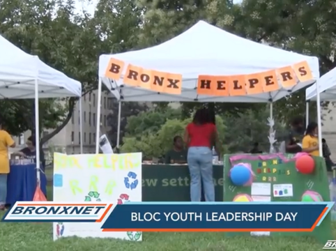 Tents with banners displaying 'BRONX HELPERS' at BLOC youth leadership day event.