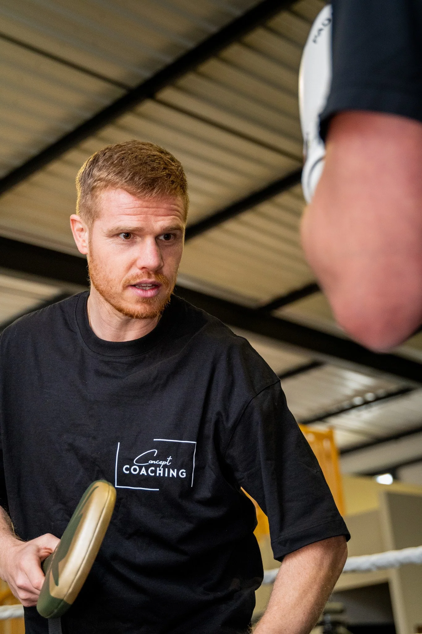 Un entraîneur de coaching en discuter avec un athlète dans une salle d'entraînement de boxe.
