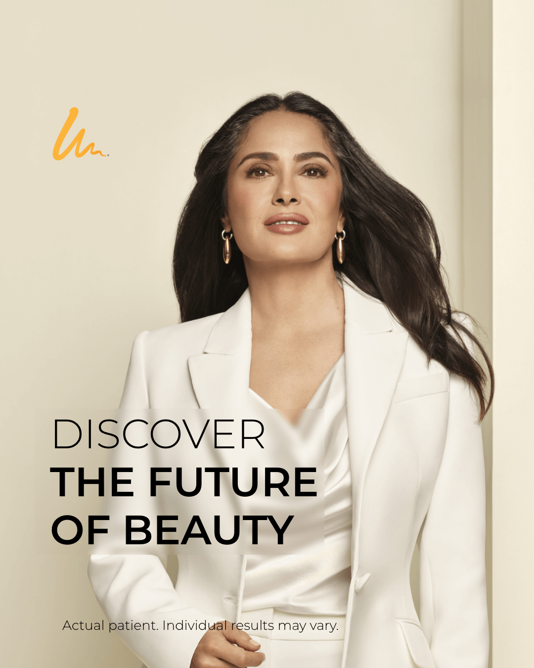 A woman with long dark hair, wearing a white blazer and gold earrings, standing against a light background with a subtle gradient. The text on the image reads, 'Discover the future of beauty.'