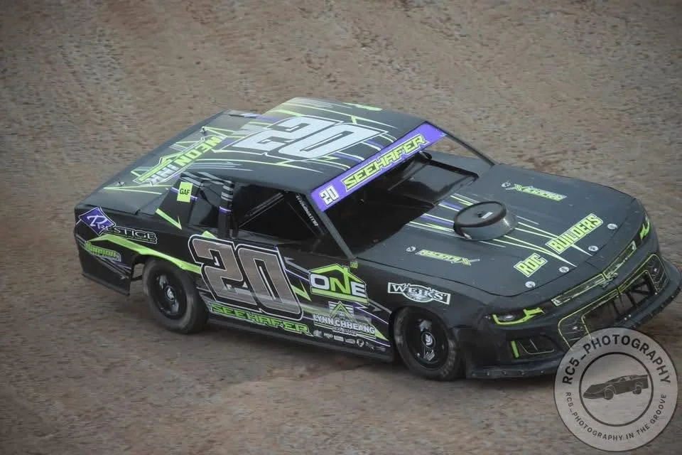 ROC Builders sponsors this racing car with yellow and purple accents on a dirt track, featuring the number 20 and various sponsor logos.